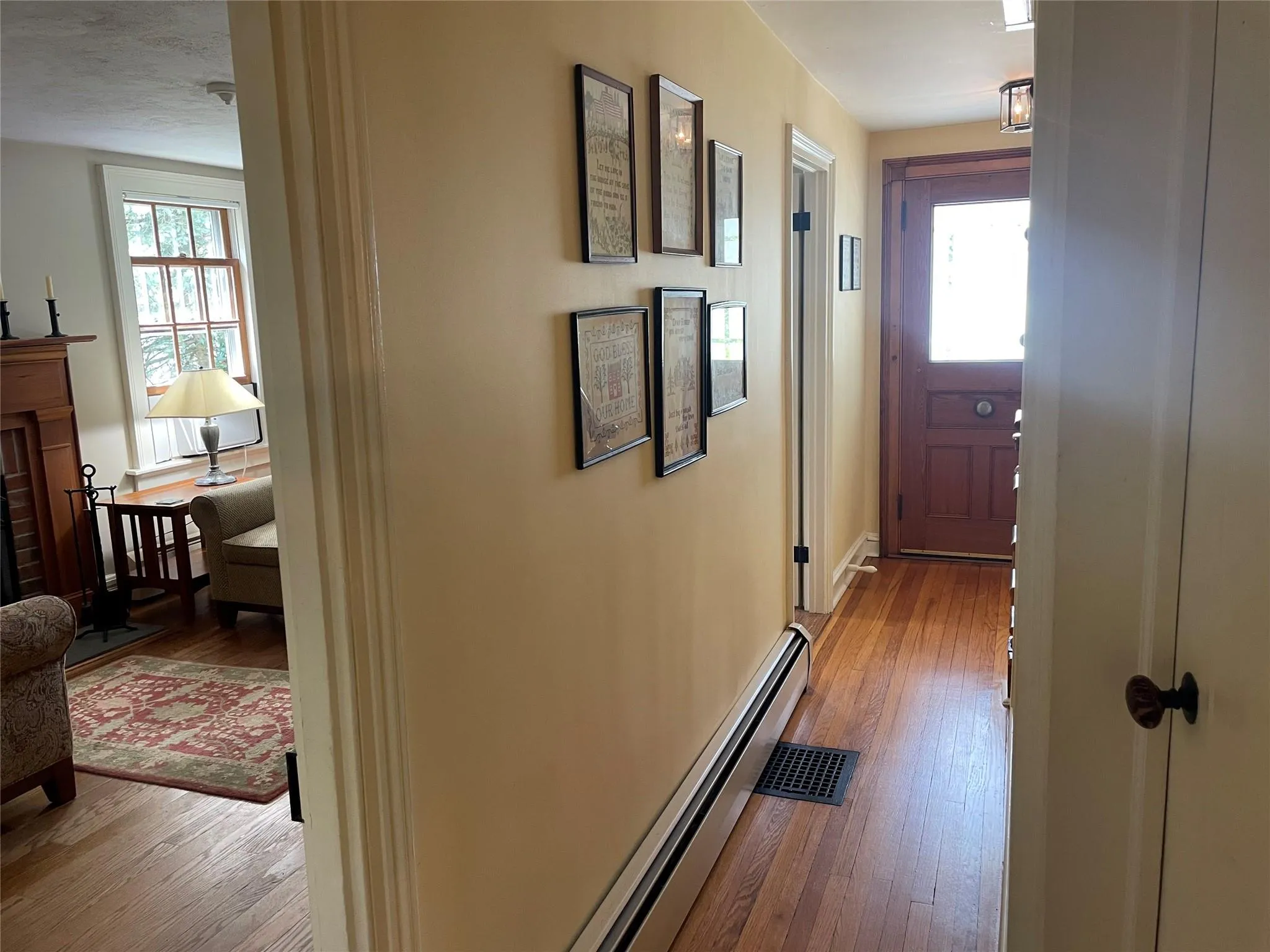 Hallway featuring a baseboard radiator, wood-type flooring, and healthy amount of natural light Hallway featuring a baseboard radiator, wood-type flooring, and healthy amount of natural light