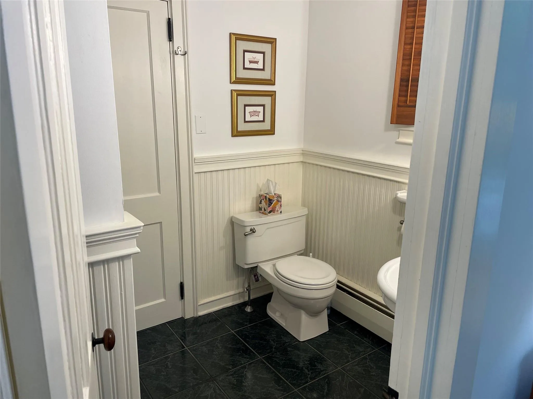 Bathroom with wainscoting, a baseboard radiator, and marble finish floors Bathroom with wainscoting, a baseboard radiator, and marble finish floors