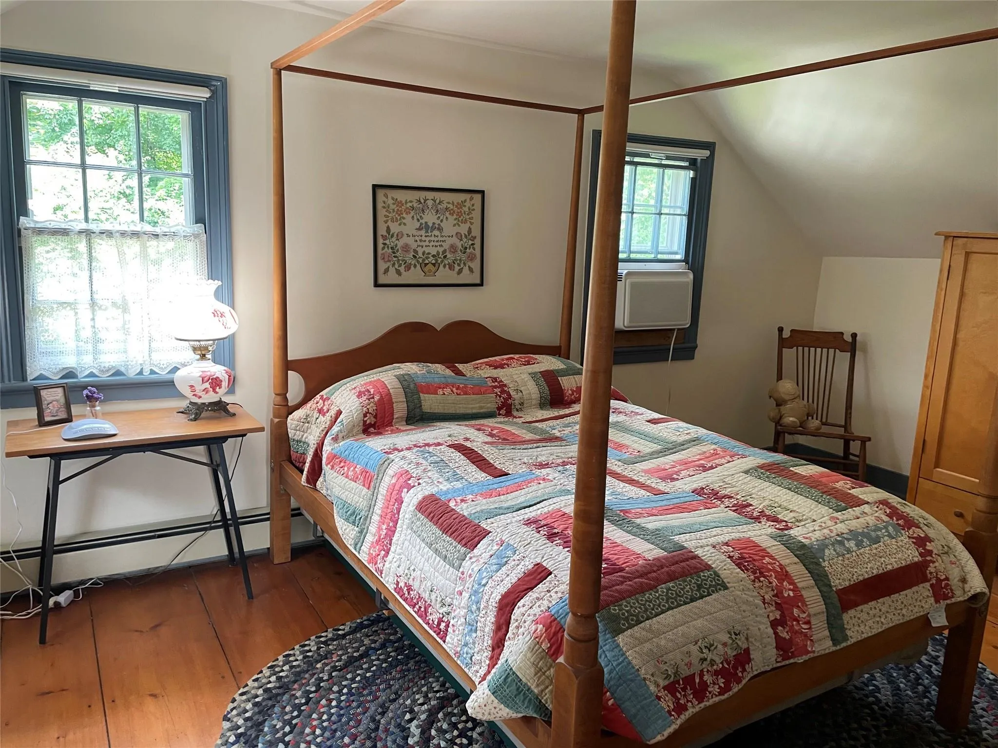 Bedroom featuring hardwood / wood-style floors, lofted ceiling, and a baseboard radiator Bedroom featuring hardwood / wood-style floors, lofted ceiling, and a baseboard radiator