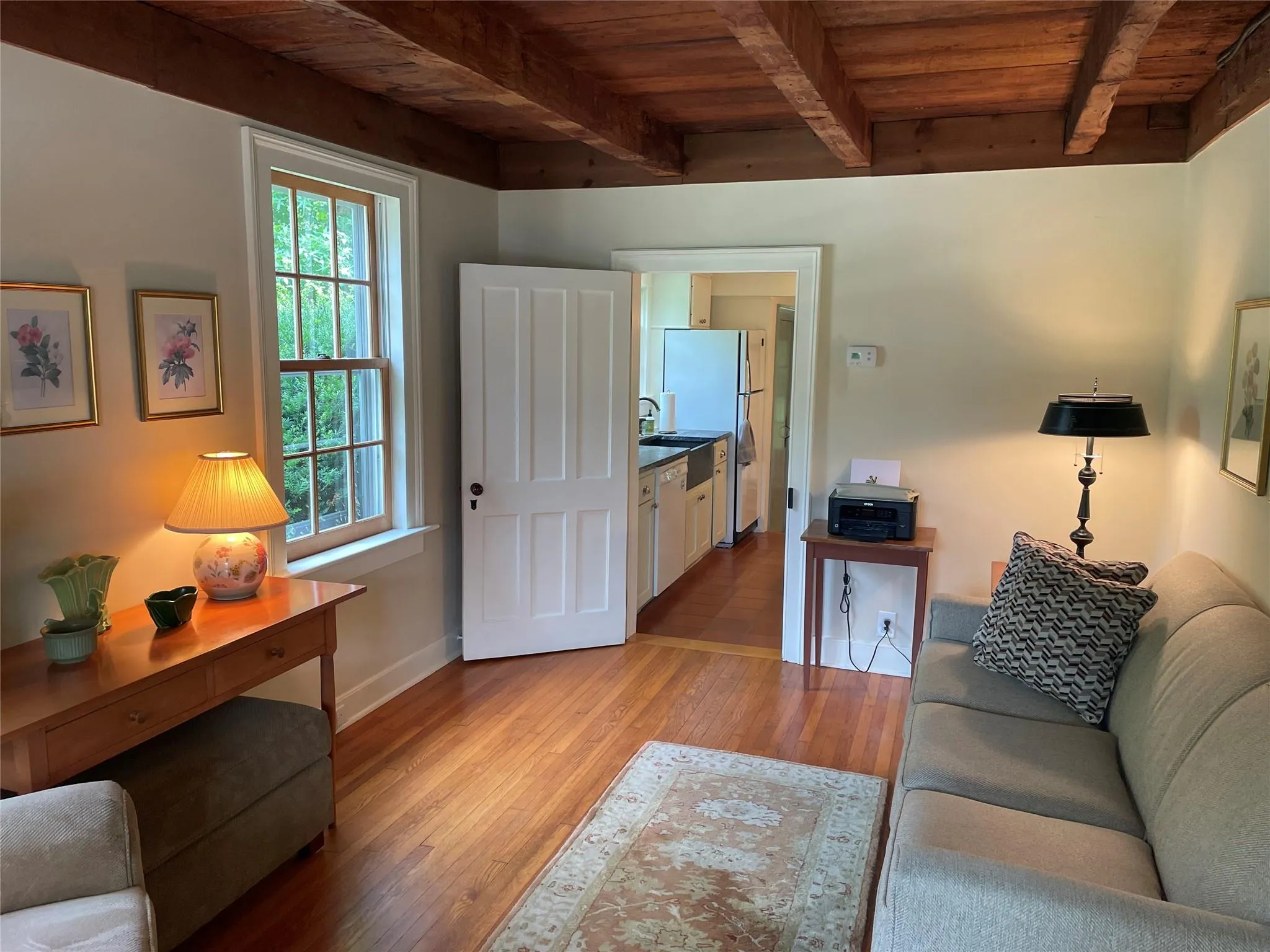 Living area featuring a wood ceiling with exposed beams and light wood-style flooring Living area featuring a wood ceiling with exposed beams and light wood-style flooring