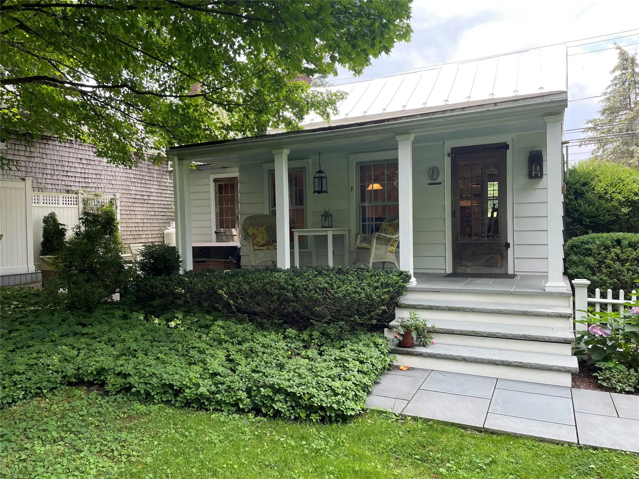 View of front of home featuring a porch, a standing seam roof, and a metal roof View of front of home featuring a porch, a standing seam roof, and a metal roof