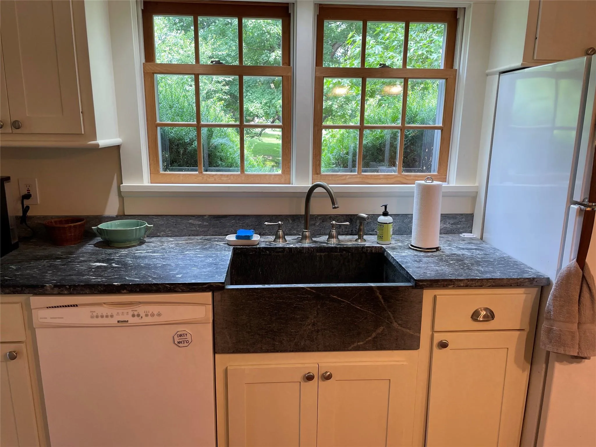 Kitchen featuring white appliances and dark countertops Kitchen featuring white appliances and dark countertops