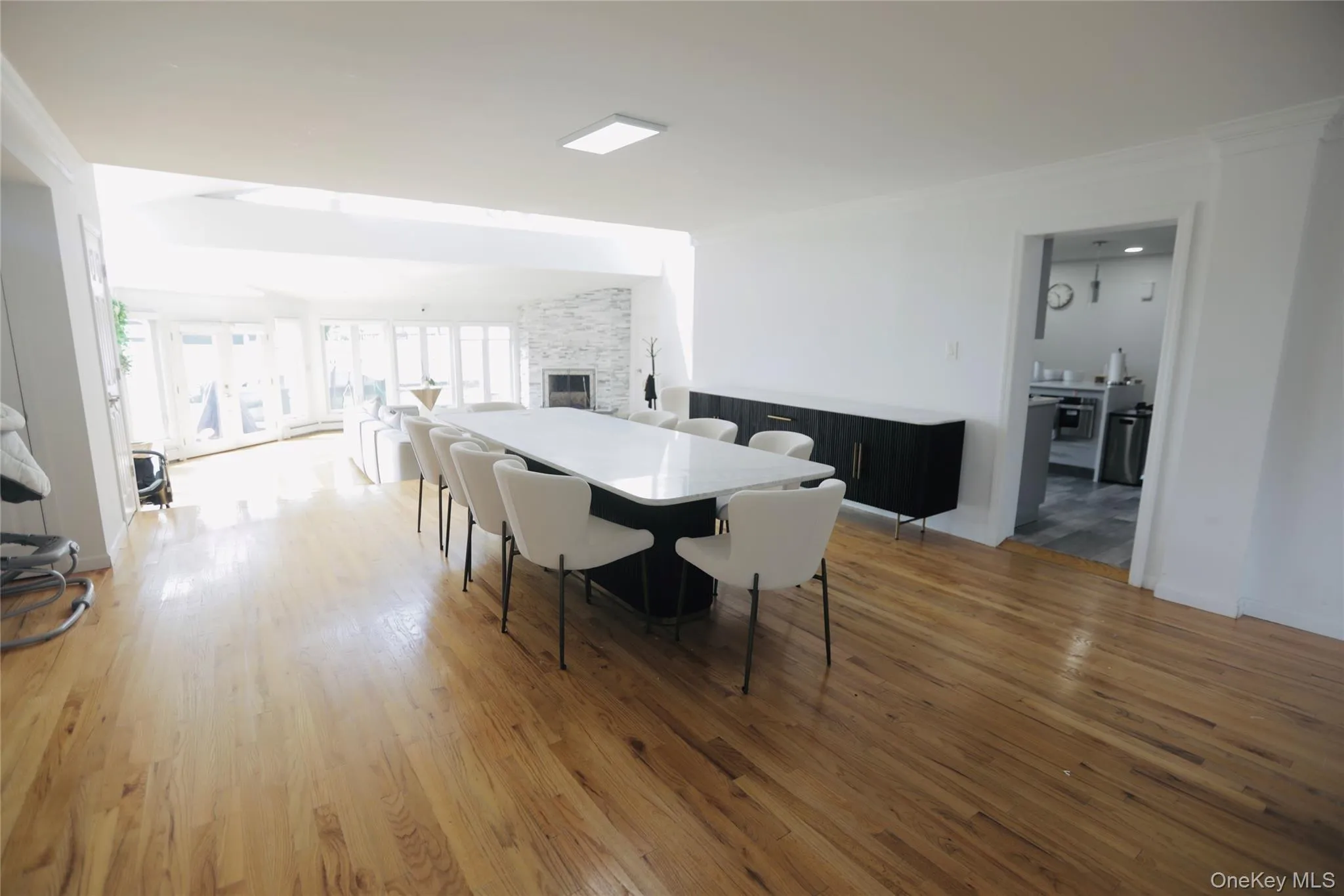 Dining space featuring light wood-style flooring, a fireplace, and crown molding Dining space featuring light wood-style flooring, a fireplace, and crown molding