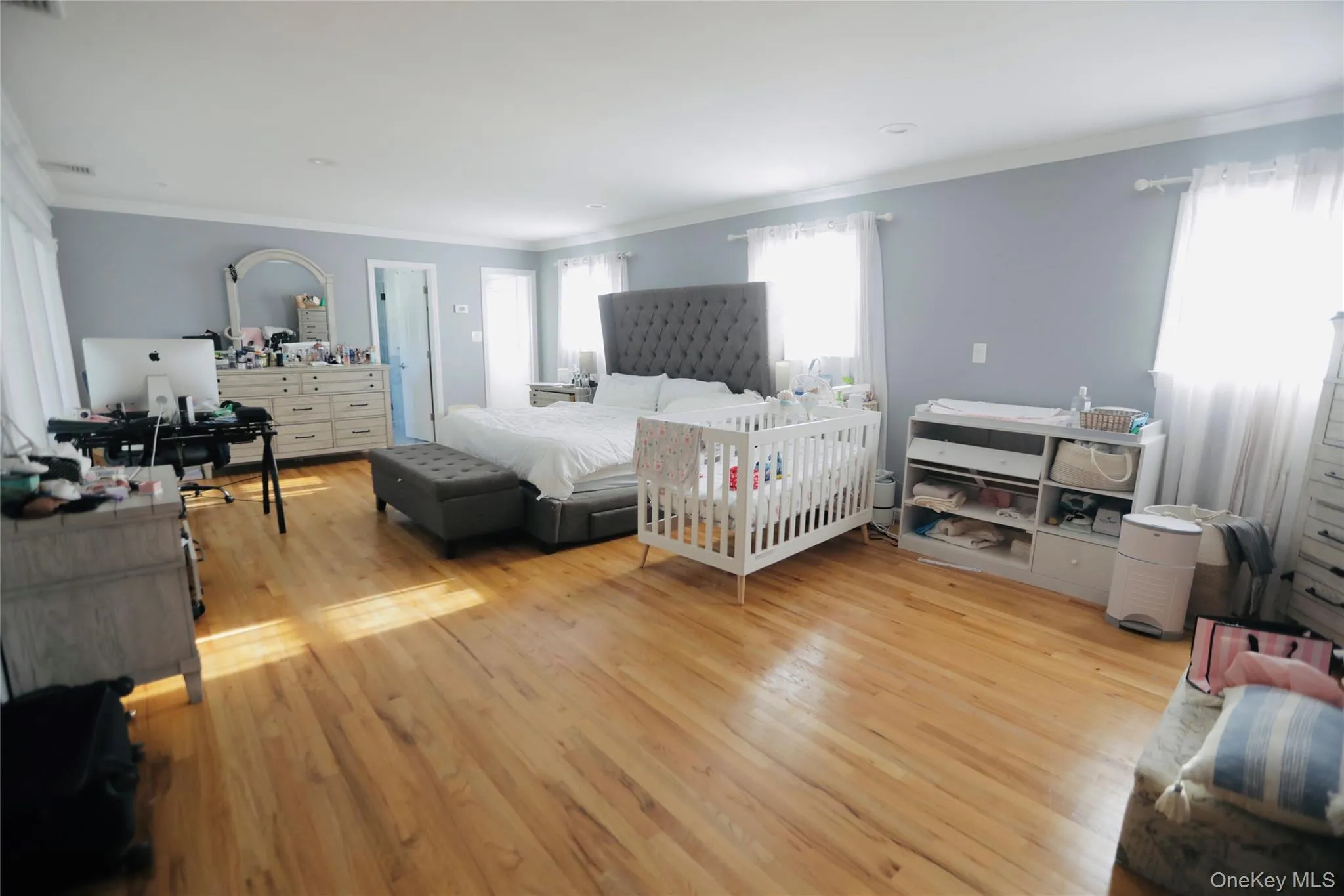 Bedroom featuring crown molding and light wood finished floors Bedroom featuring crown molding and light wood finished floors