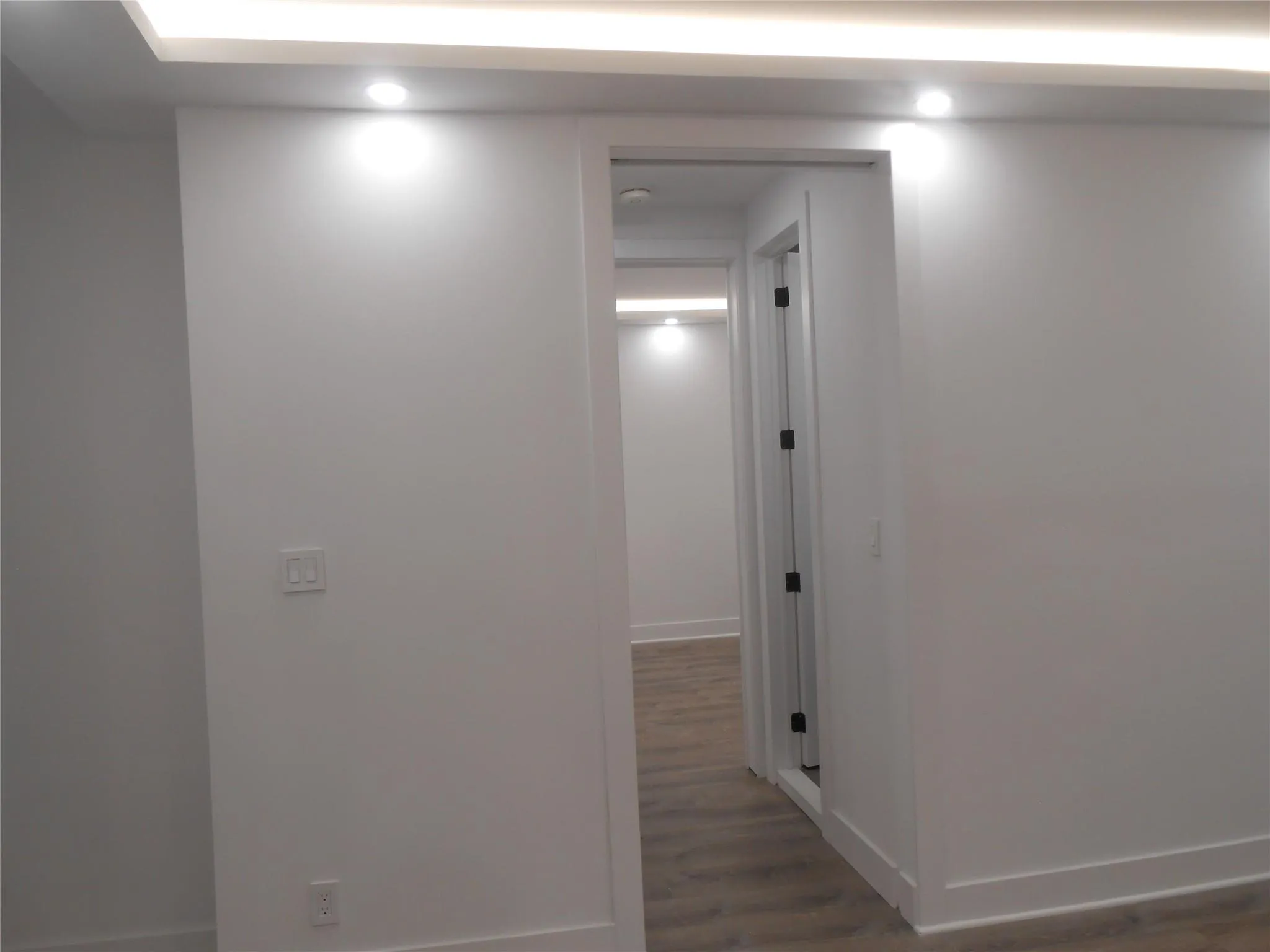 Hallway featuring wood finished floors and recessed lighting Hallway featuring wood finished floors and recessed lighting
