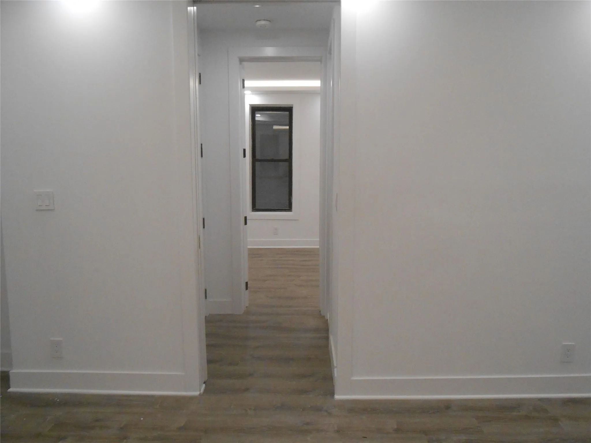 Corridor featuring baseboards and wood finished floors Corridor featuring baseboards and wood finished floors