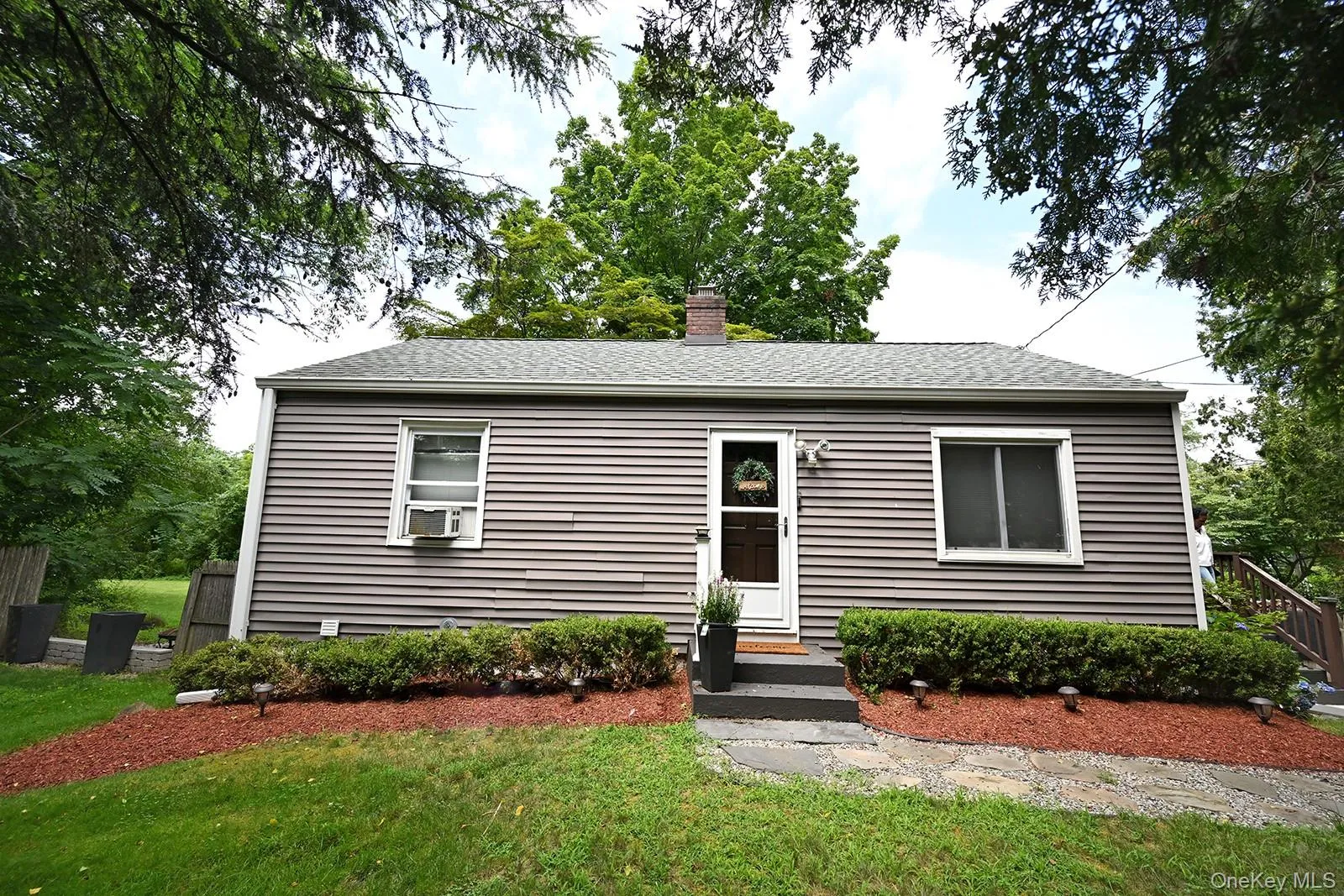 View of front of home with a front yard, a chimney, and a shingled roof View of front of home with a front yard, a chimney, and a shingled roof