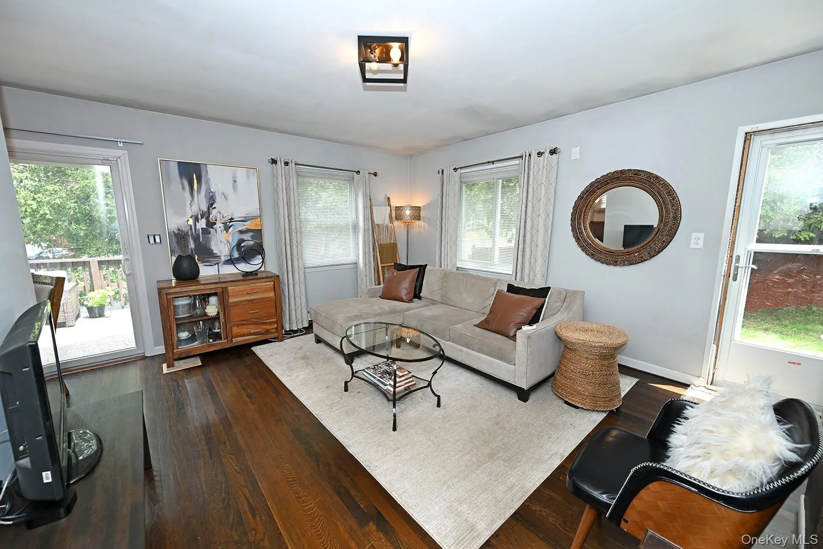 Living room with dark wood-type flooring and healthy amount of natural light Living room with dark wood-type flooring and healthy amount of natural light