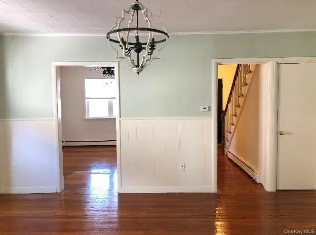 Dining area featuring molding, chandelier and hardwood flooring Dining area featuring molding, chandelier and hardwood flooring