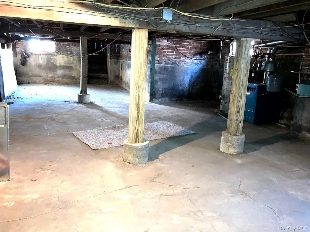 Below grade area featuring a heating unit and water heater Below grade area featuring a heating unit and water heater