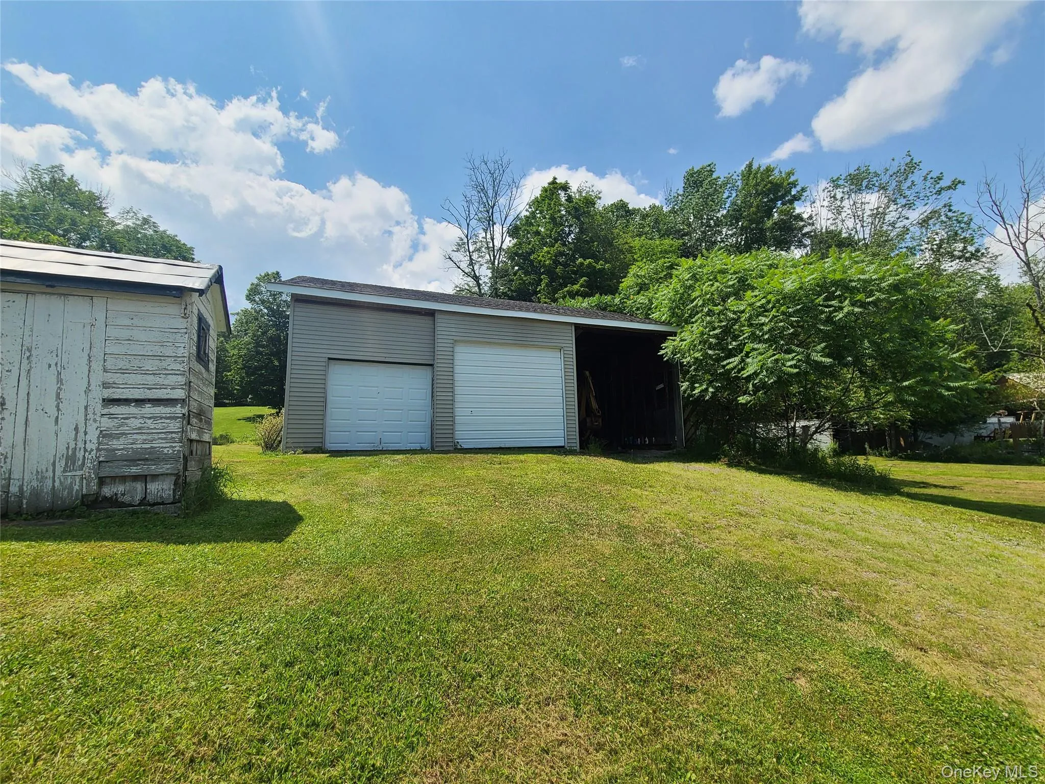 View of green lawn with an outbuilding and a garage View of green lawn with an outbuilding and a garage