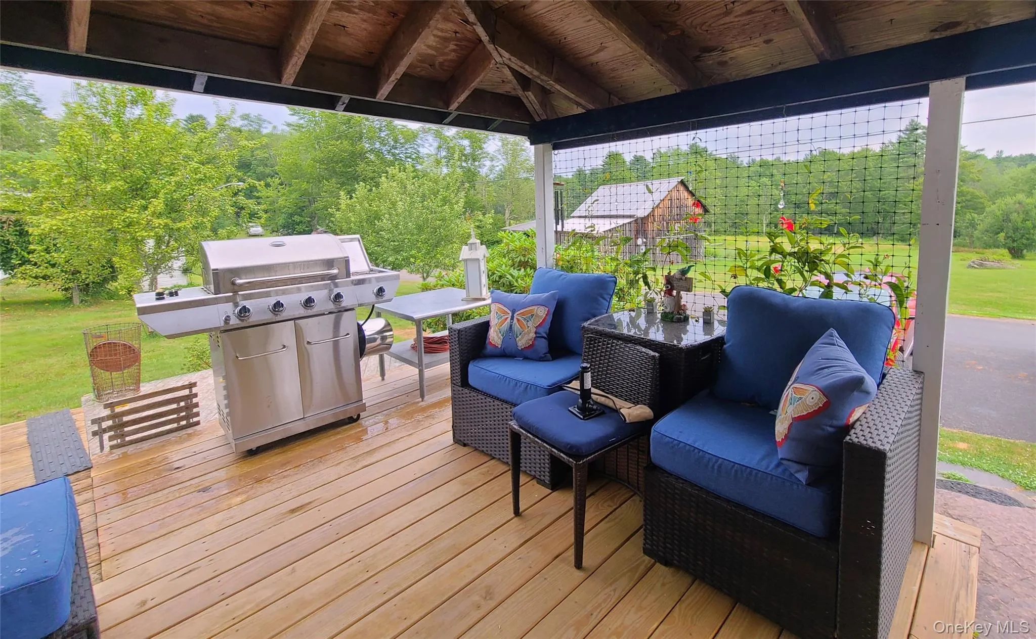 Wooden terrace featuring a grill Wooden terrace featuring a grill