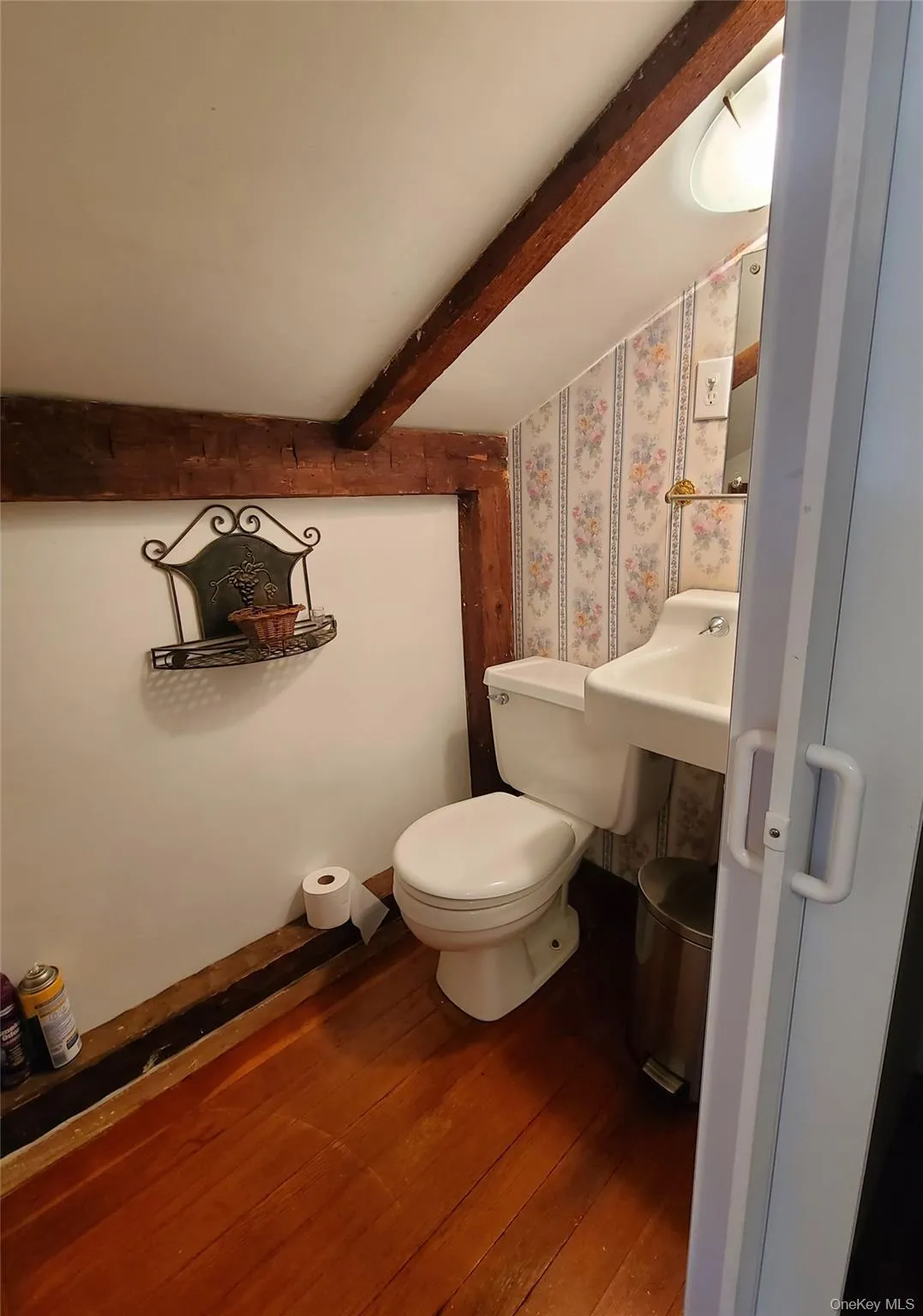 Bathroom with beamed ceiling, hardwood / wood-style flooring, and wallpapered walls Bathroom with beamed ceiling, hardwood / wood-style flooring, and wallpapered walls