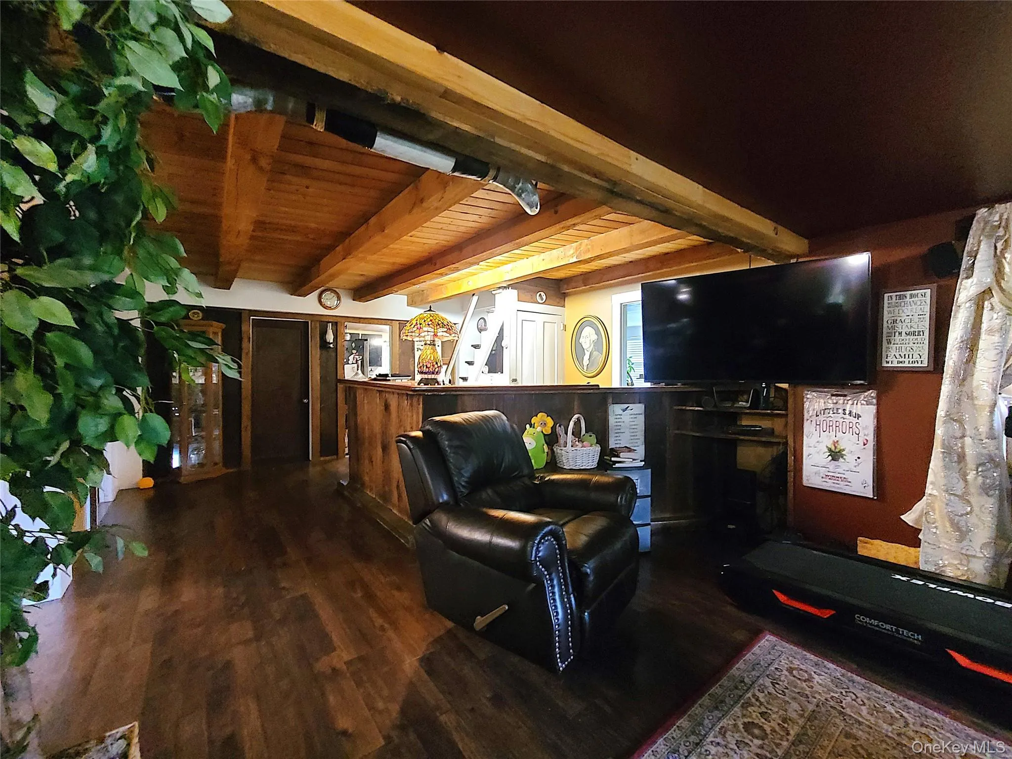 Living area featuring a wooden ceiling with exposed beams and wood finished floors Living area featuring a wooden ceiling with exposed beams and wood finished floors
