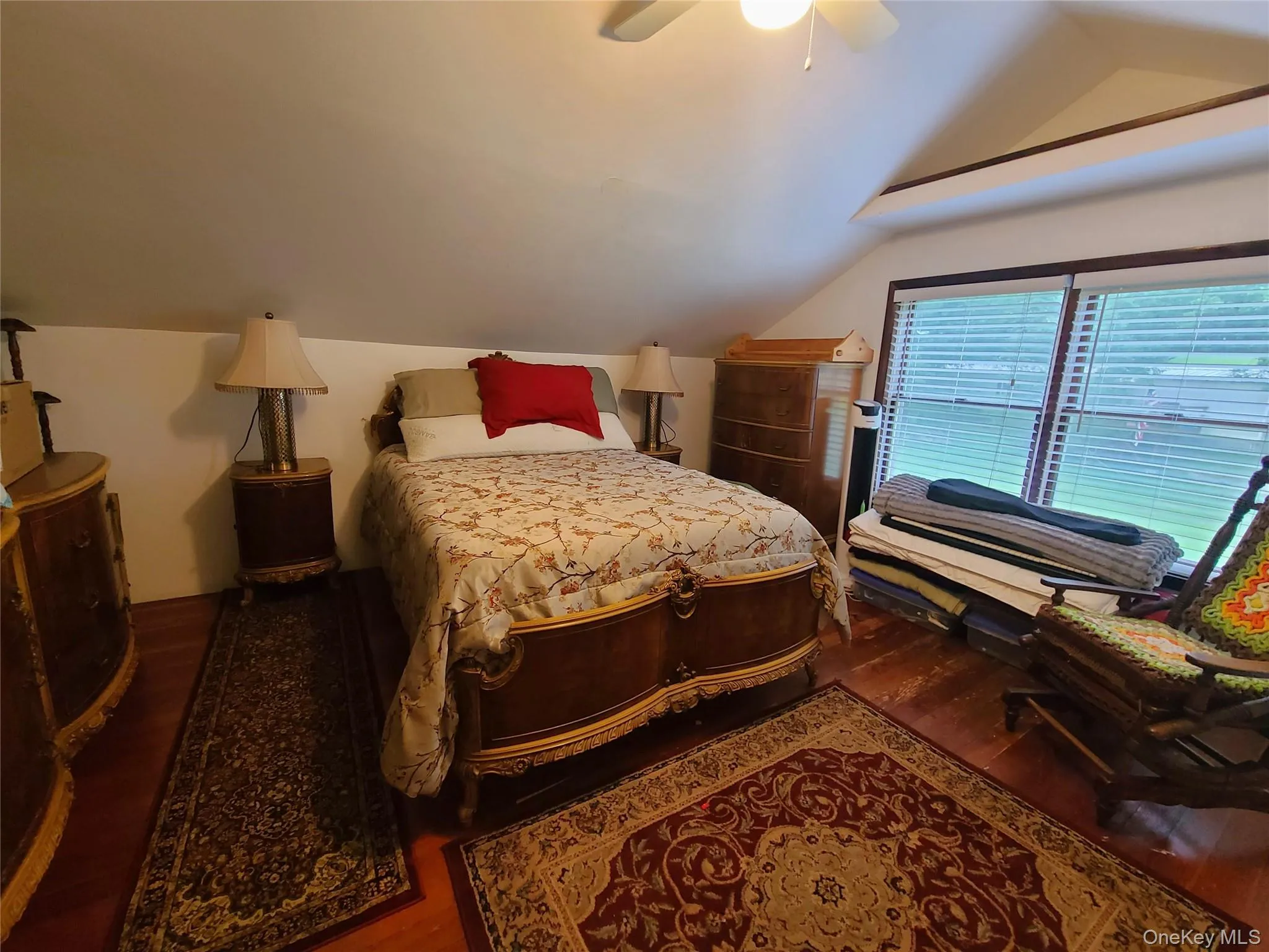 Bedroom with wood finished floors, vaulted ceiling, and a ceiling fan Bedroom with wood finished floors, vaulted ceiling, and a ceiling fan