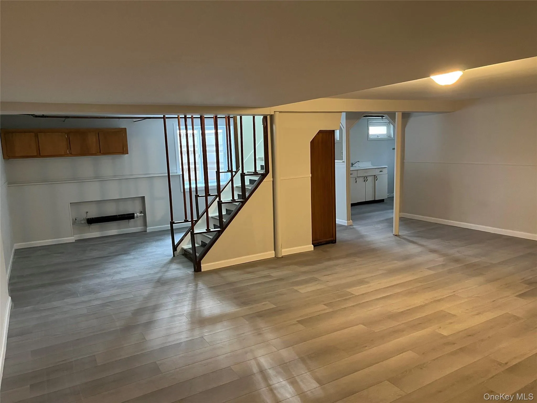 Basement featuring vinyl planked floors, egress window and radiator Basement featuring vinyl planked floors, egress window and radiator