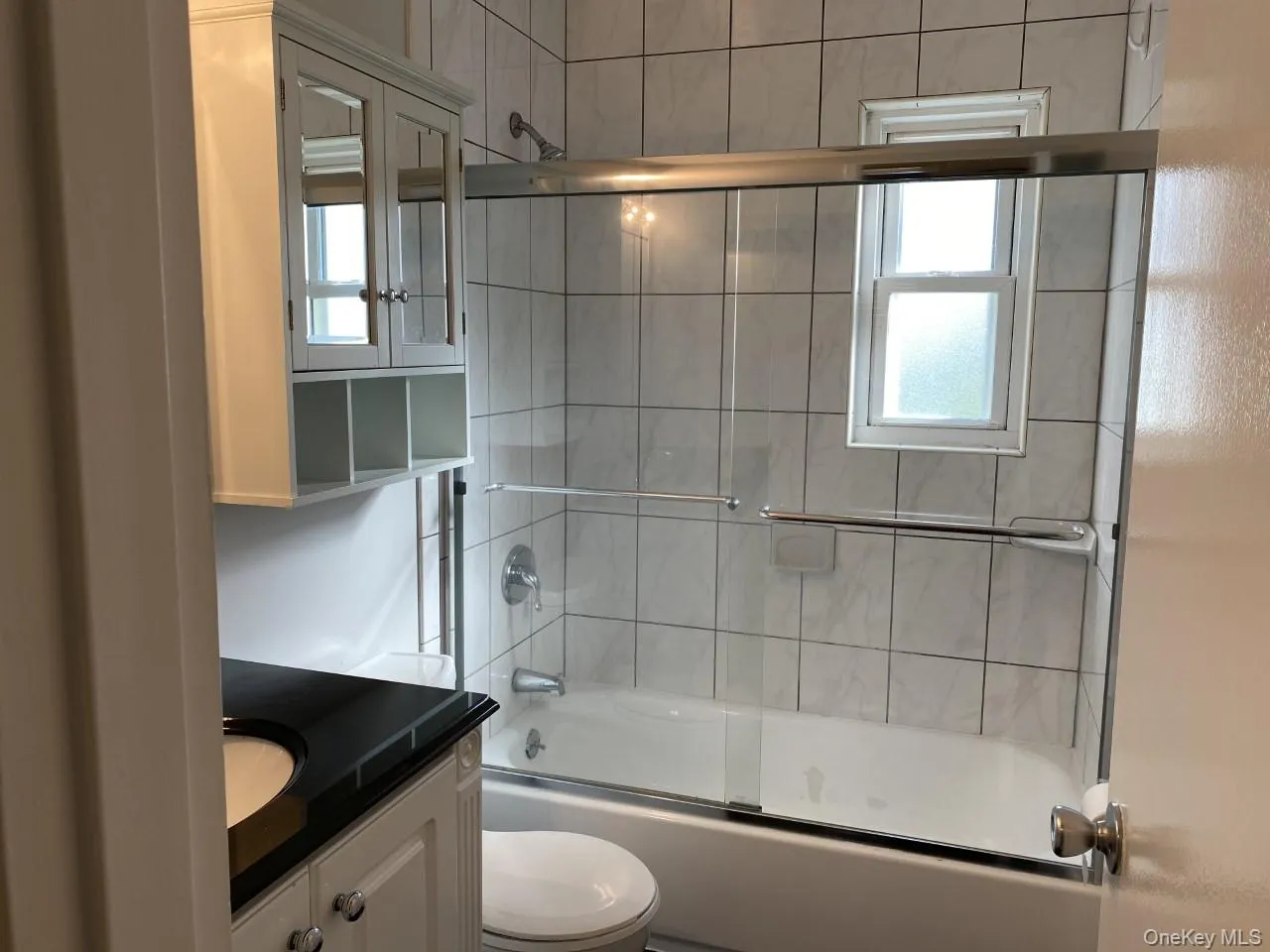 Full bathroom featuring vanity, plenty of natural light, and combined bath / shower with glass door Full bathroom featuring vanity, plenty of natural light, and combined bath / shower with glass door