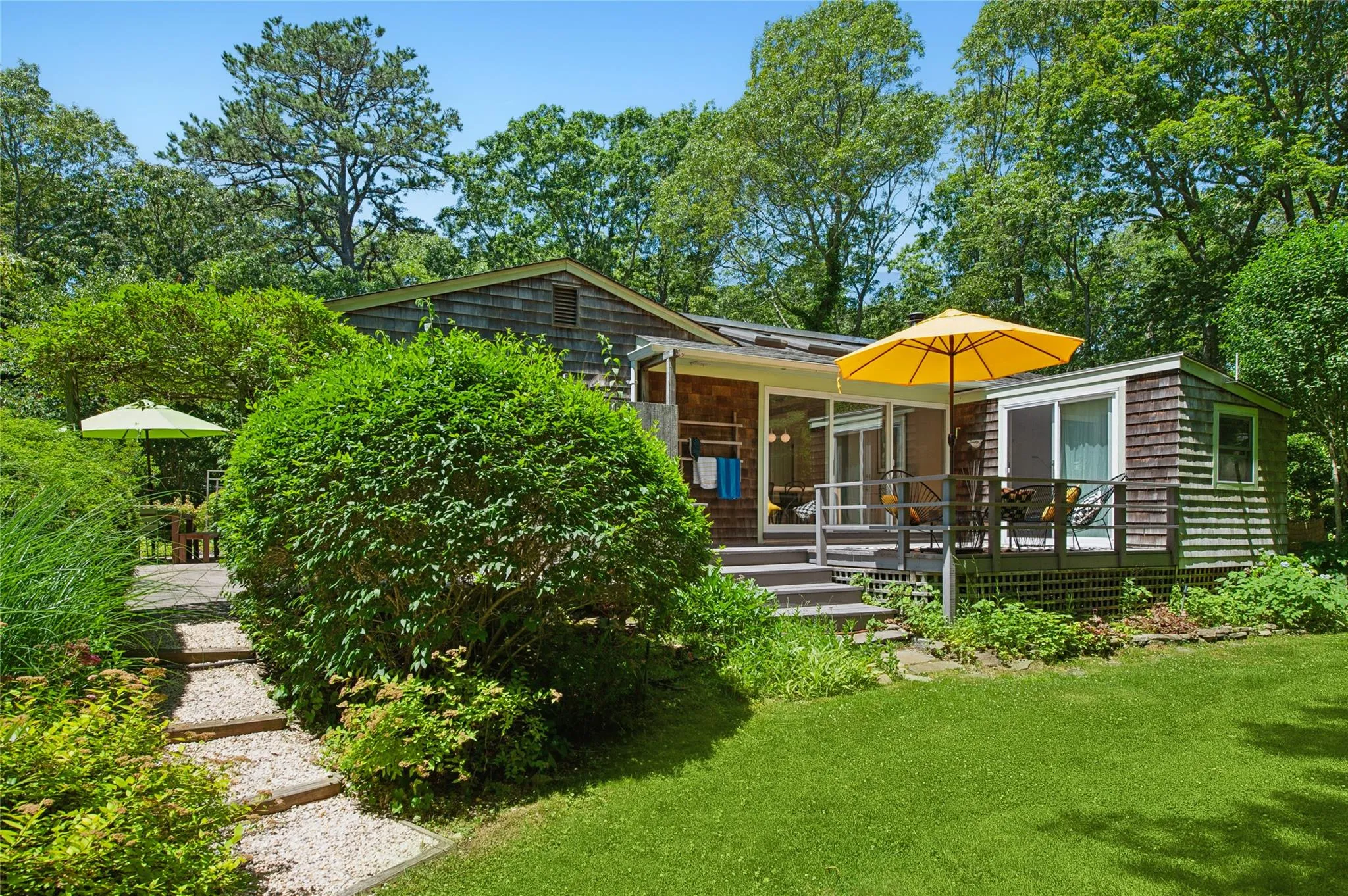 Back of house with a lawn, a sunroom, and a wooden deck Back of house with a lawn, a sunroom, and a wooden deck