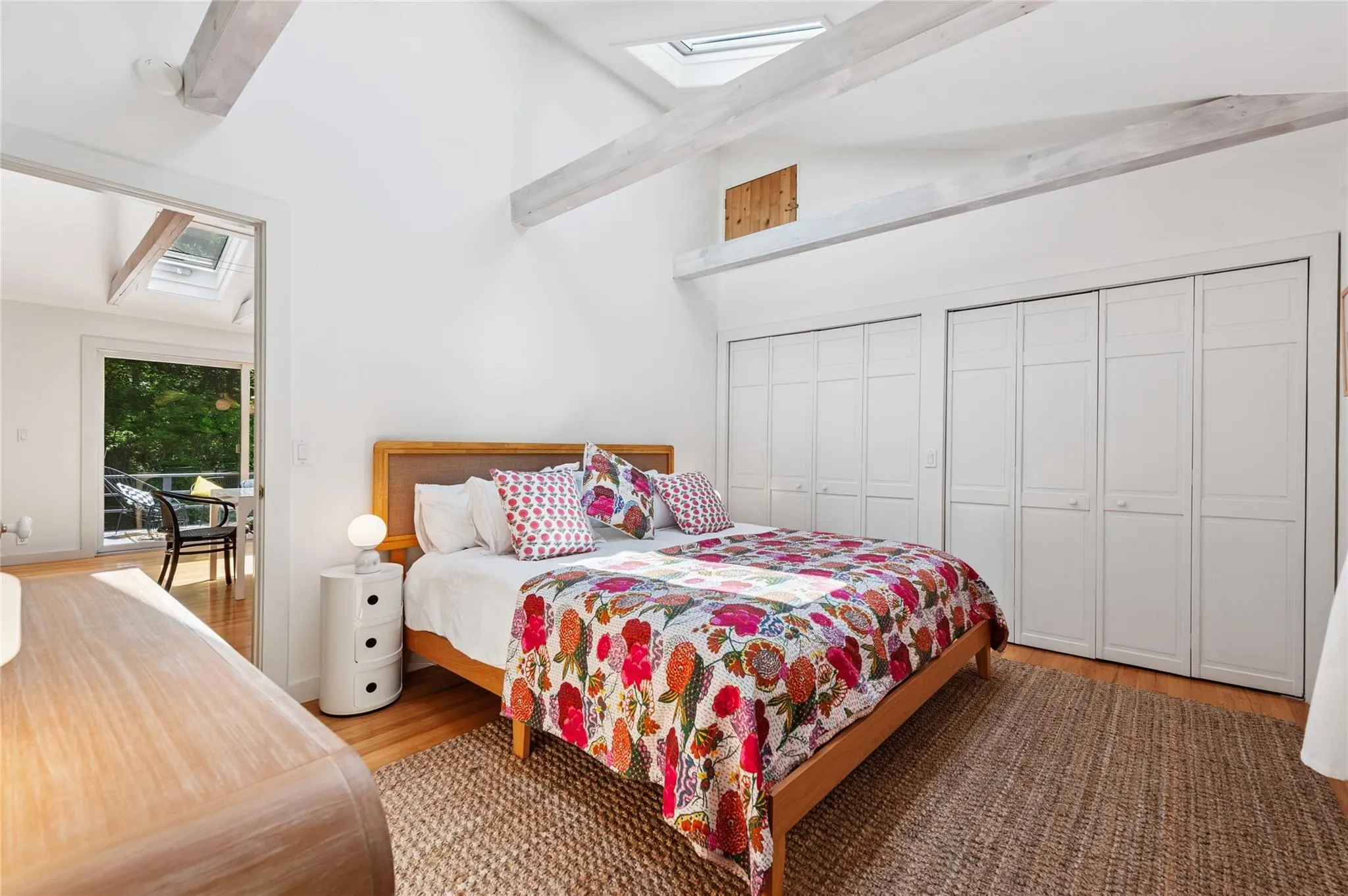 Bedroom featuring a skylight, wood finished floors, multiple closets, and lofted ceiling Bedroom featuring a skylight, wood finished floors, multiple closets, and lofted ceiling