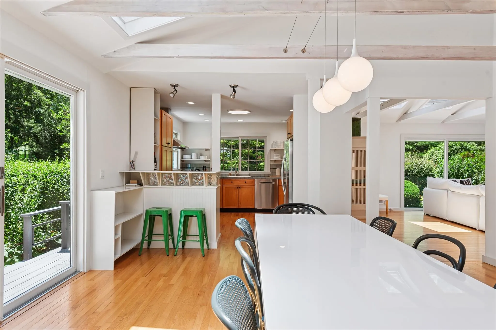 Dining space with a skylight, plenty of natural light, light wood-type flooring, and beamed ceiling Dining space with a skylight, plenty of natural light, light wood-type flooring, and beamed ceiling
