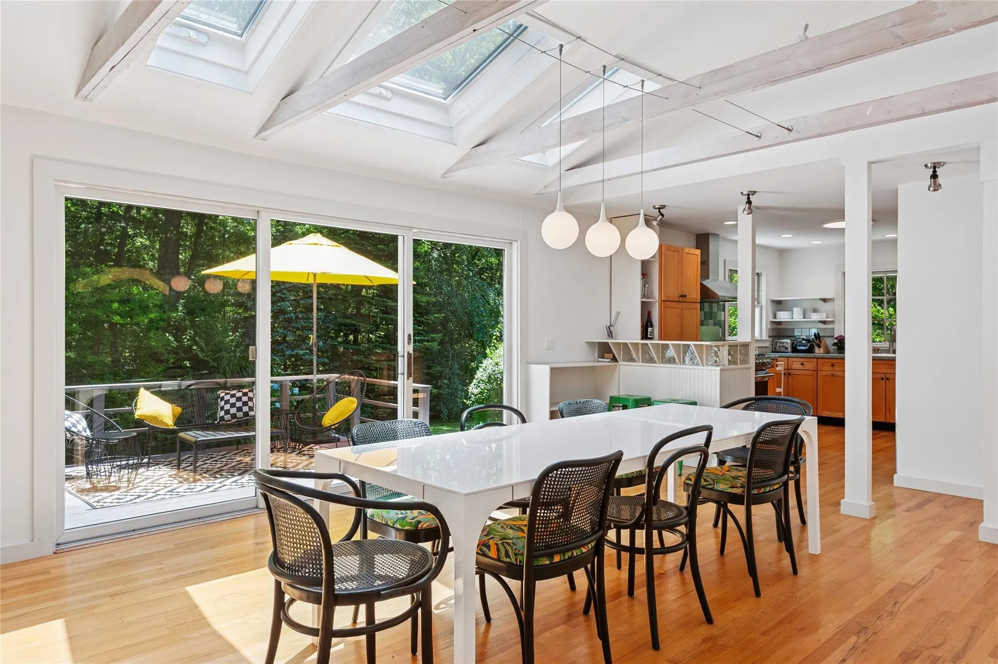 Dining room with a skylight, plenty of natural light, light wood-style flooring, and beam ceiling Dining room with a skylight, plenty of natural light, light wood-style flooring, and beam ceiling