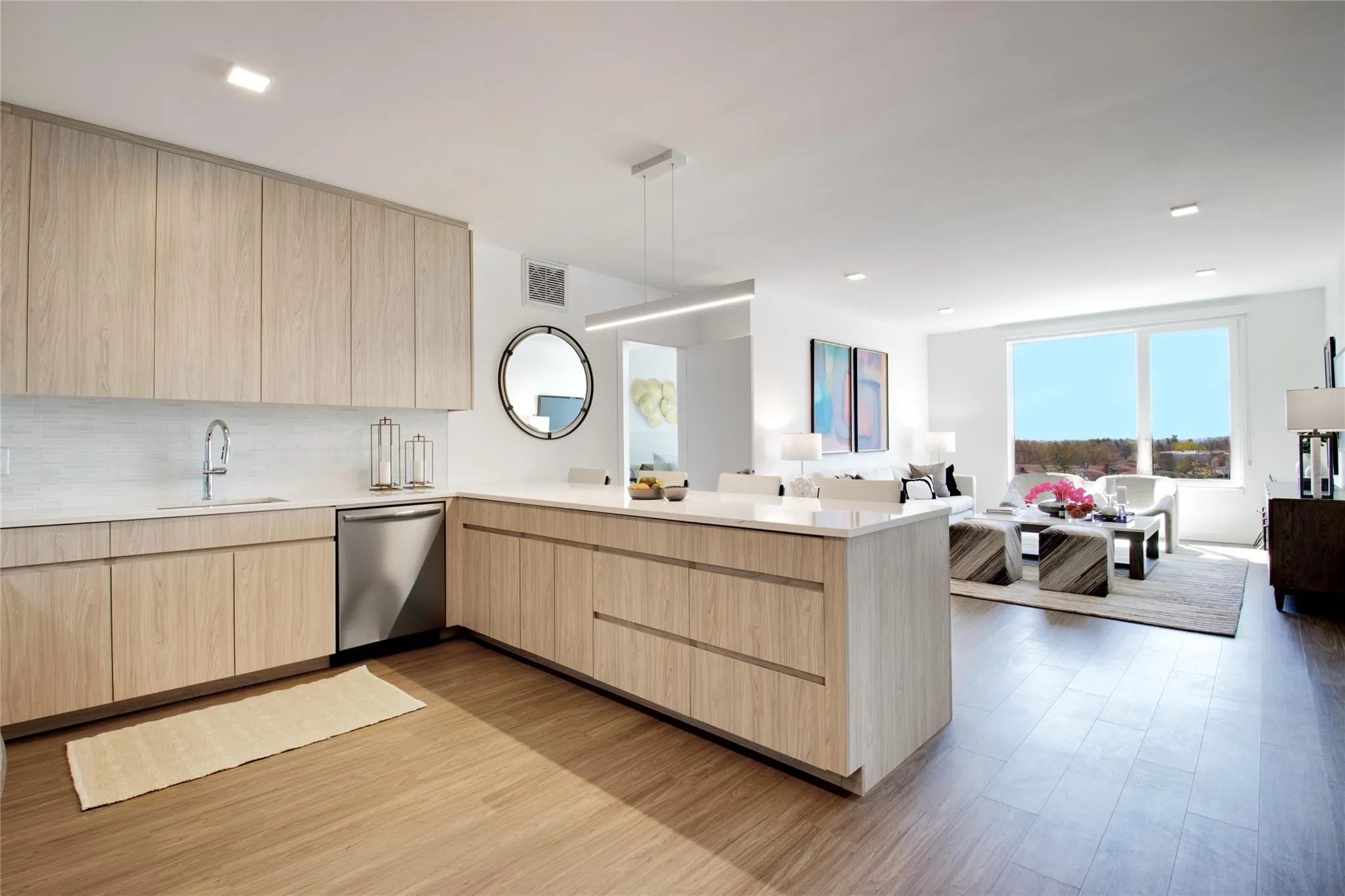 Kitchen featuring light brown cabinetry, modern cabinets, open floor plan, a peninsula, and light countertops Kitchen featuring light brown cabinetry, modern cabinets, open floor plan, a peninsula, and light countertops