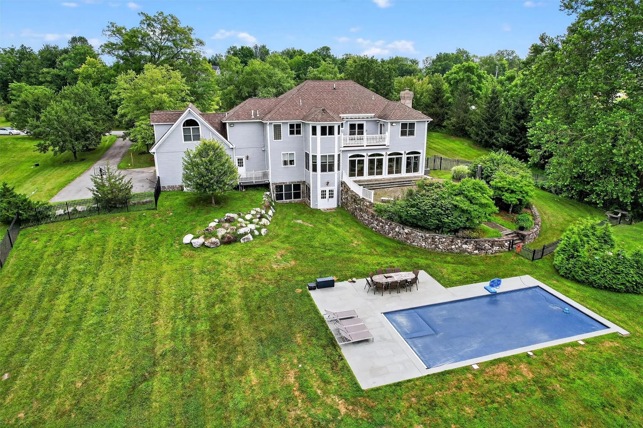 Back of house featuring a patio area, a balcony, and a chimney Back of house featuring a patio area, a balcony, and a chimney