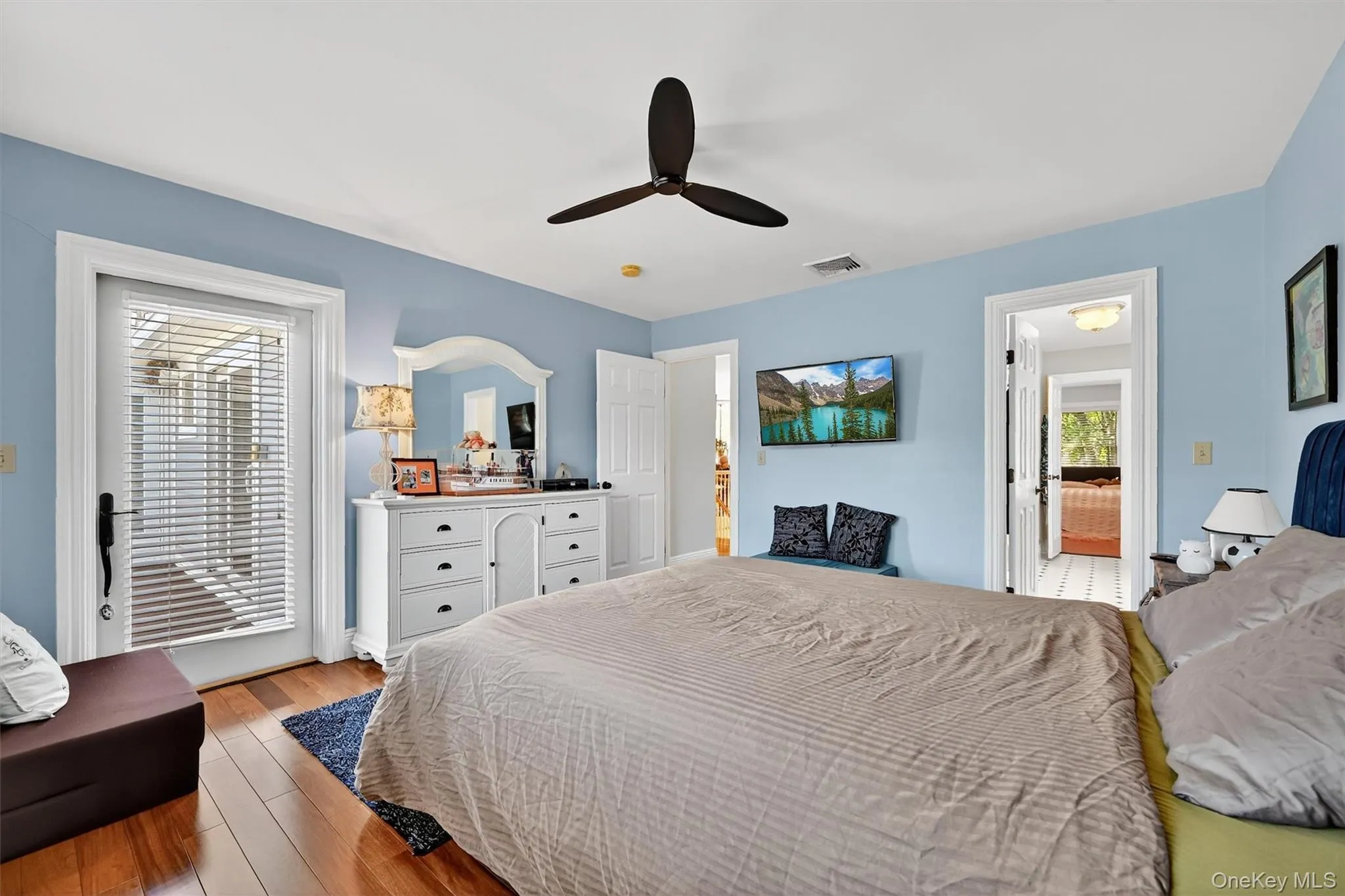 Bedroom featuring light wood finished floors and a ceiling fan Bedroom featuring light wood finished floors and a ceiling fan