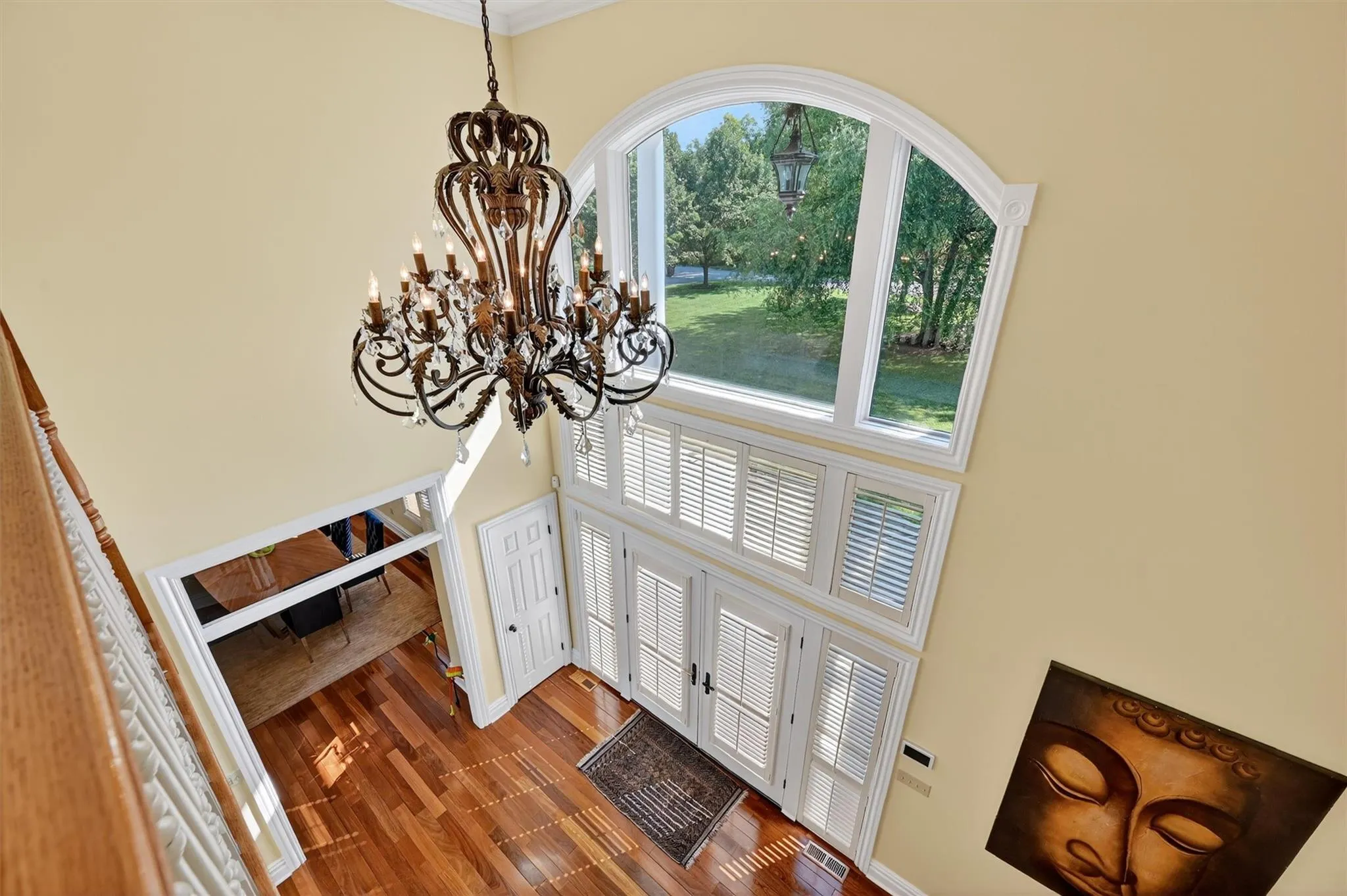 Foyer entrance with a chandelier, a high ceiling, wood finished floors, and crown molding Foyer entrance with a chandelier, a high ceiling, wood finished floors, and crown molding