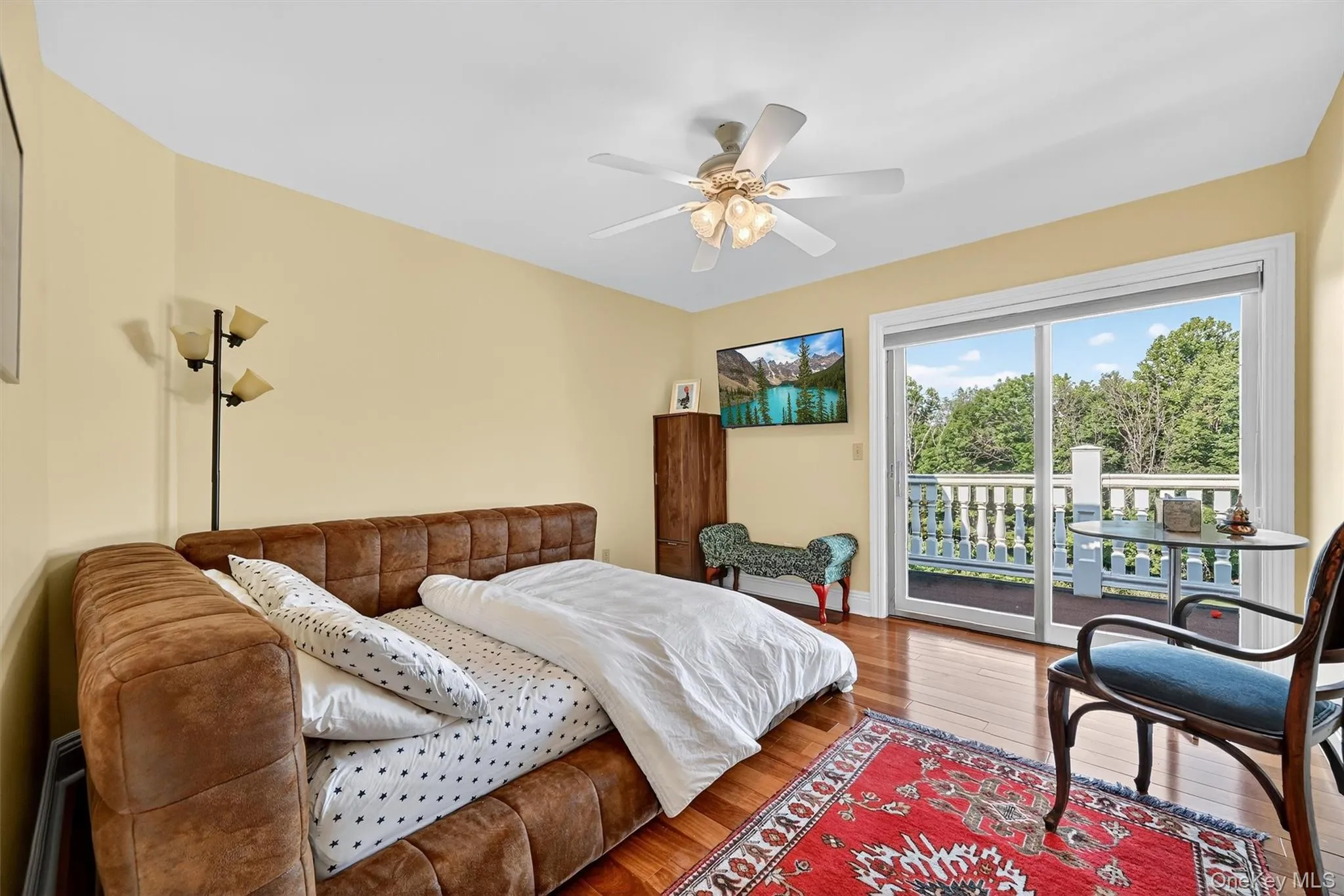 Bedroom featuring access to outside, wood-type flooring, and a ceiling fan Bedroom featuring access to outside, wood-type flooring, and a ceiling fan