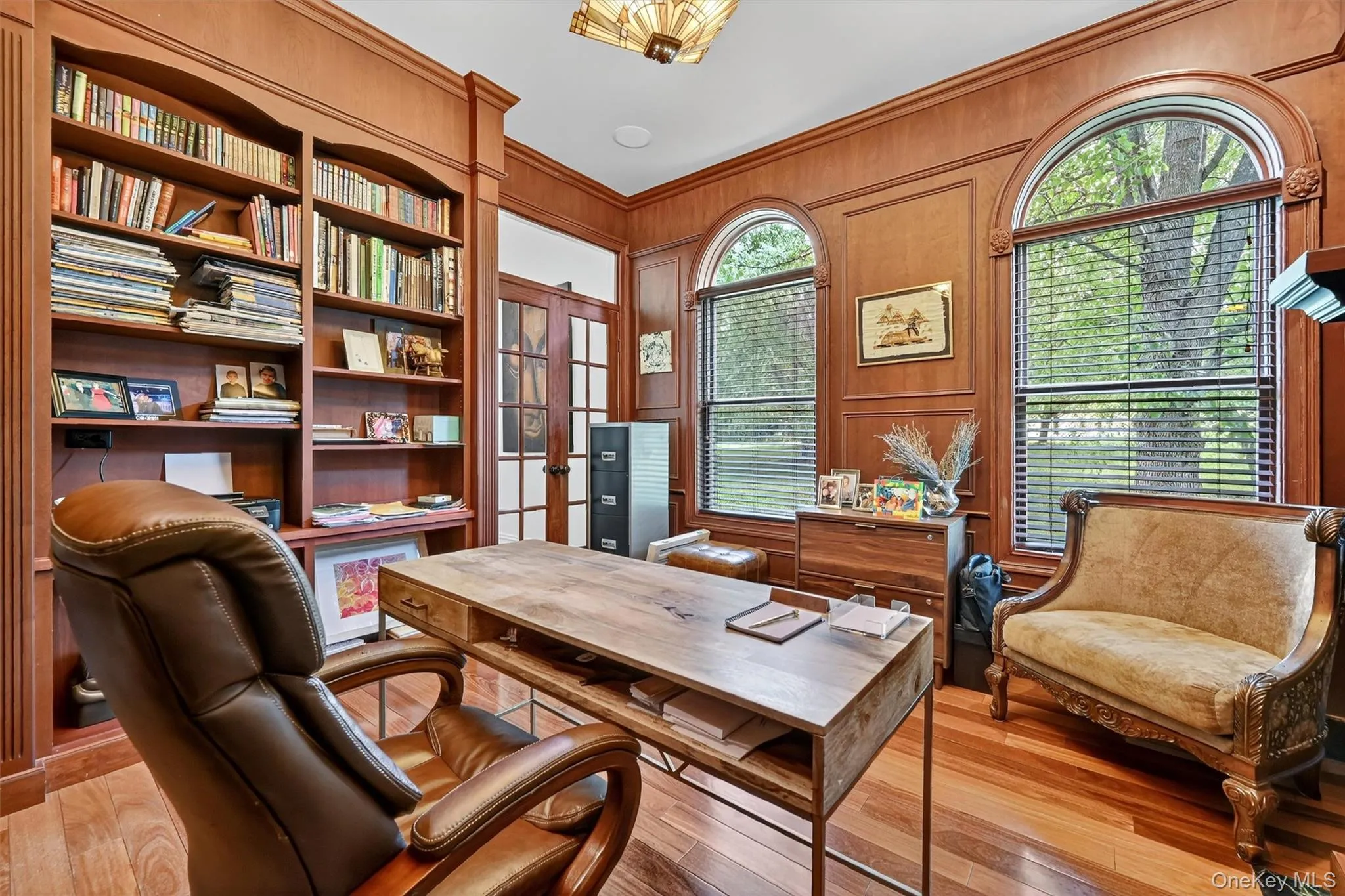 Office featuring light wood-type flooring, ornamental molding, french doors, and wooden walls Office featuring light wood-type flooring, ornamental molding, french doors, and wooden walls