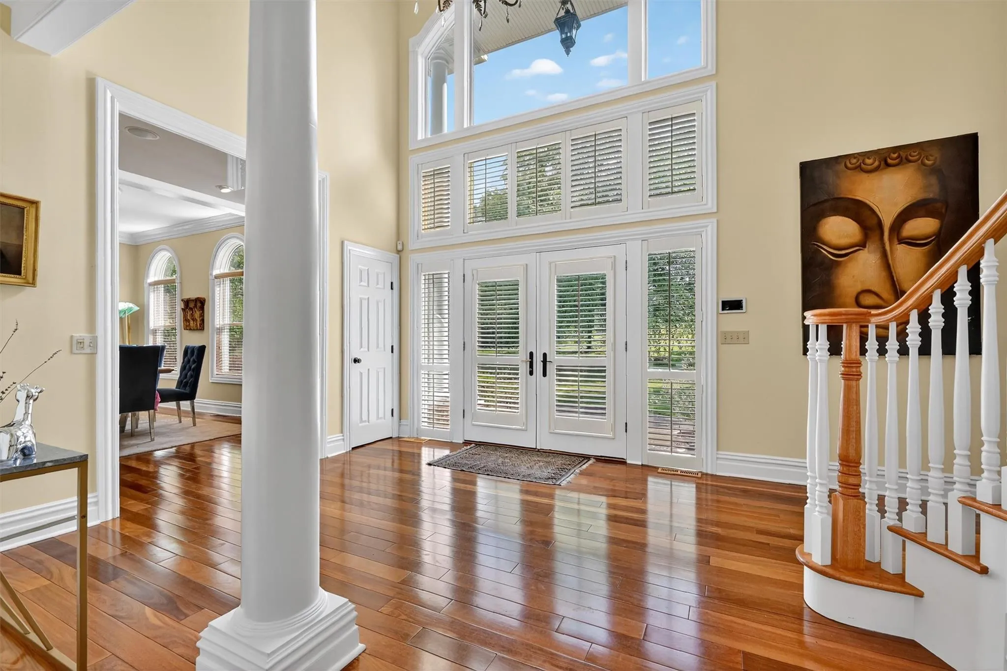Entrance foyer featuring hardwood / wood-style floors, stairs, and a high ceiling Entrance foyer featuring hardwood / wood-style floors, stairs, and a high ceiling