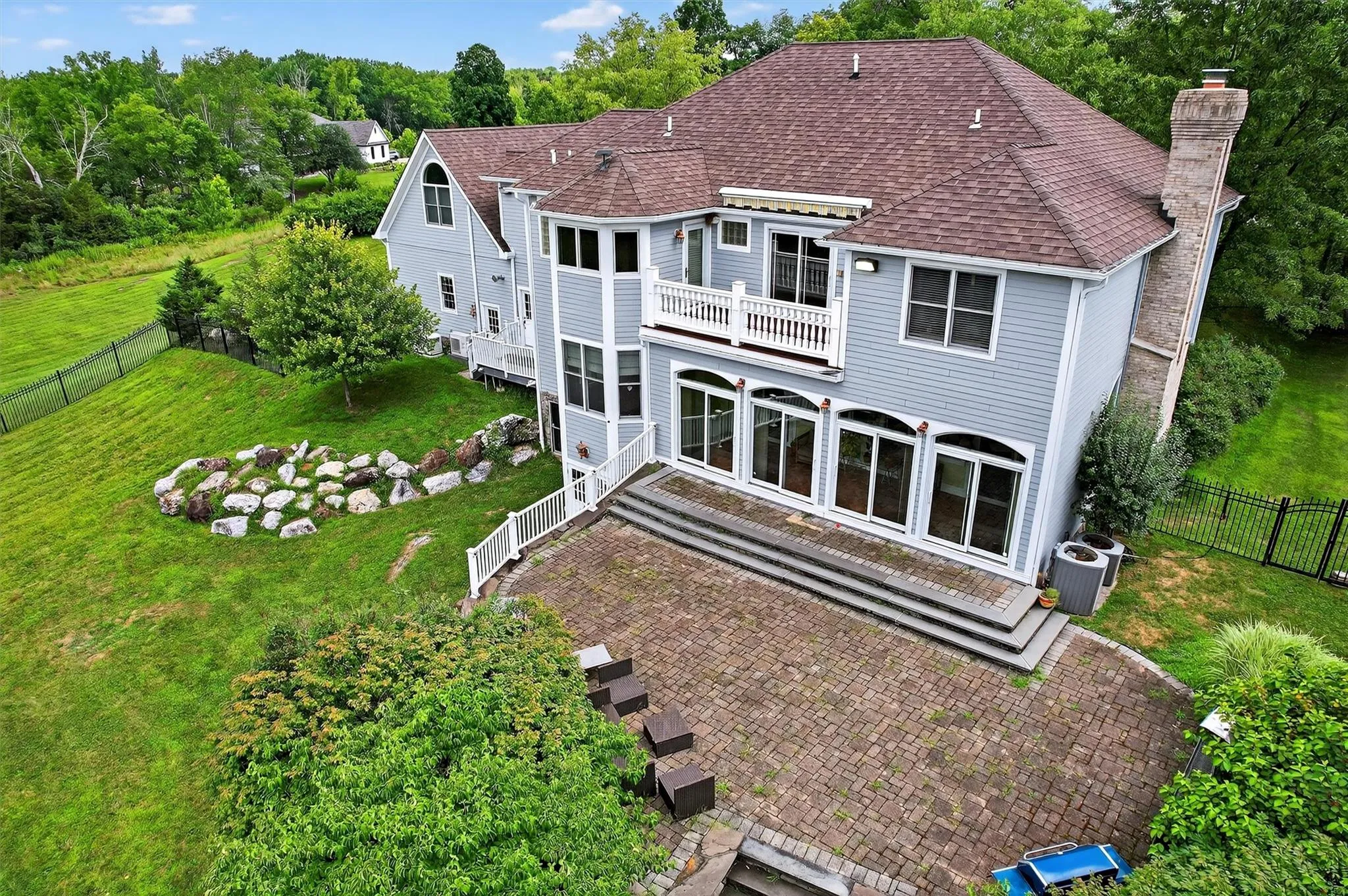 Rear view of house featuring a chimney, a fenced backyard, a deck, roof with shingles, and a patio Rear view of house featuring a chimney, a fenced backyard, a deck, roof with shingles, and a patio