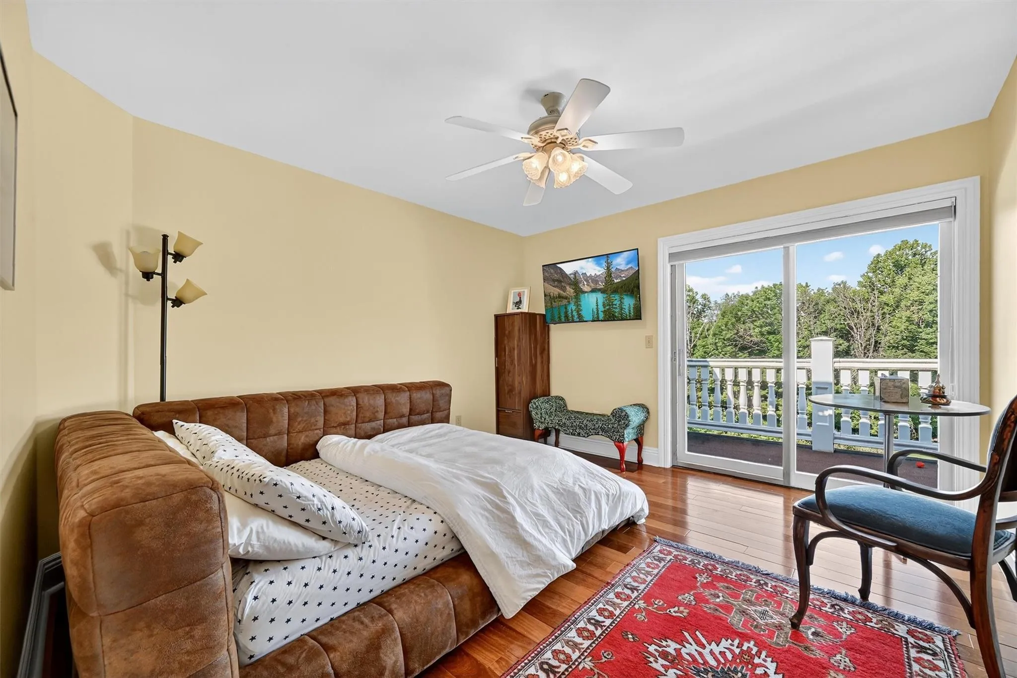 Bedroom featuring access to outside, wood-type flooring, and a ceiling fan Bedroom featuring access to outside, wood-type flooring, and a ceiling fan