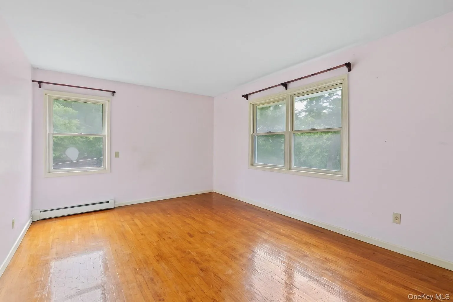 Unfurnished room featuring light wood-style floors and a baseboard radiator Unfurnished room featuring light wood-style floors and a baseboard radiator