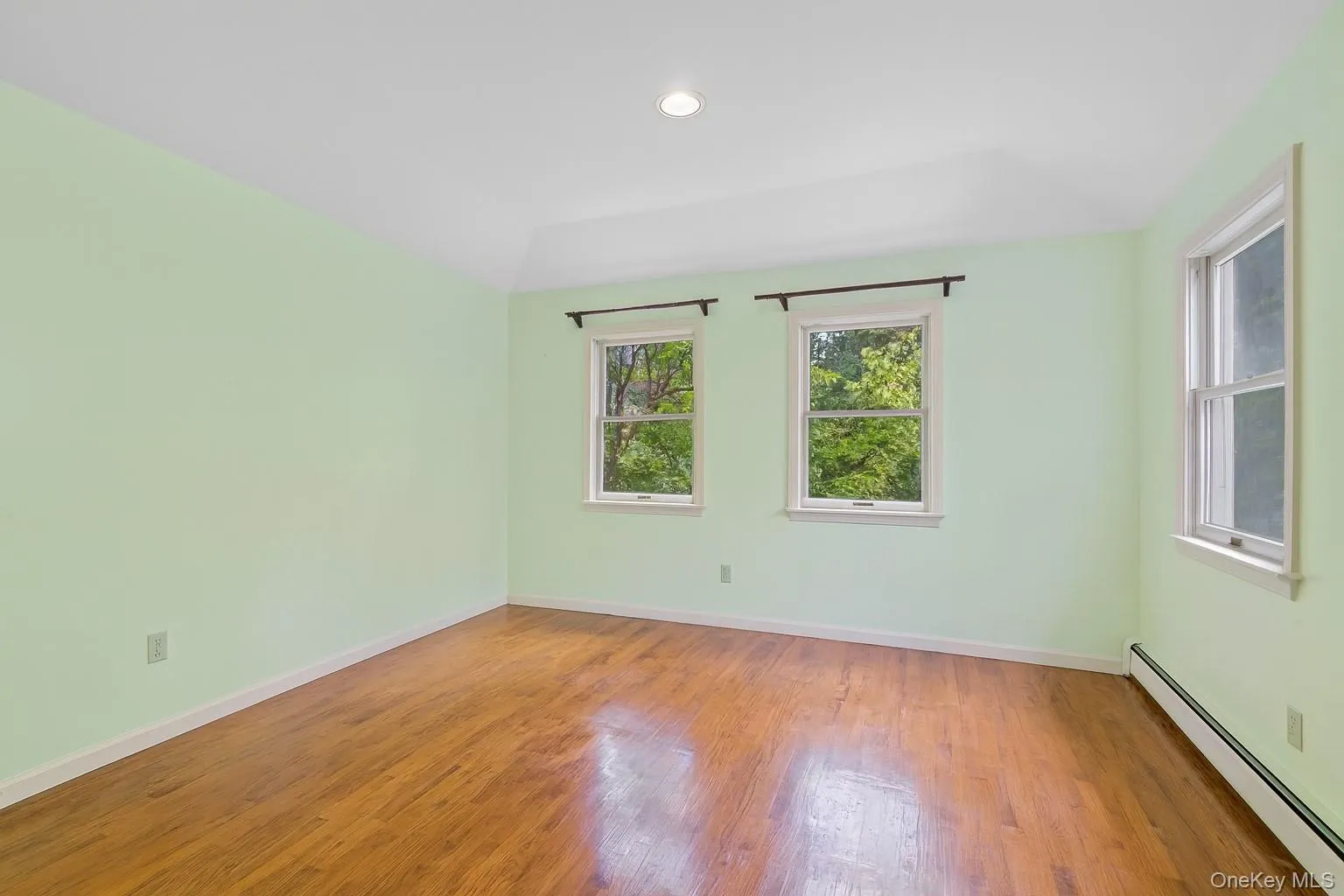 Unfurnished room with a baseboard heating unit, light wood-type flooring, and recessed lighting Unfurnished room with a baseboard heating unit, light wood-type flooring, and recessed lighting