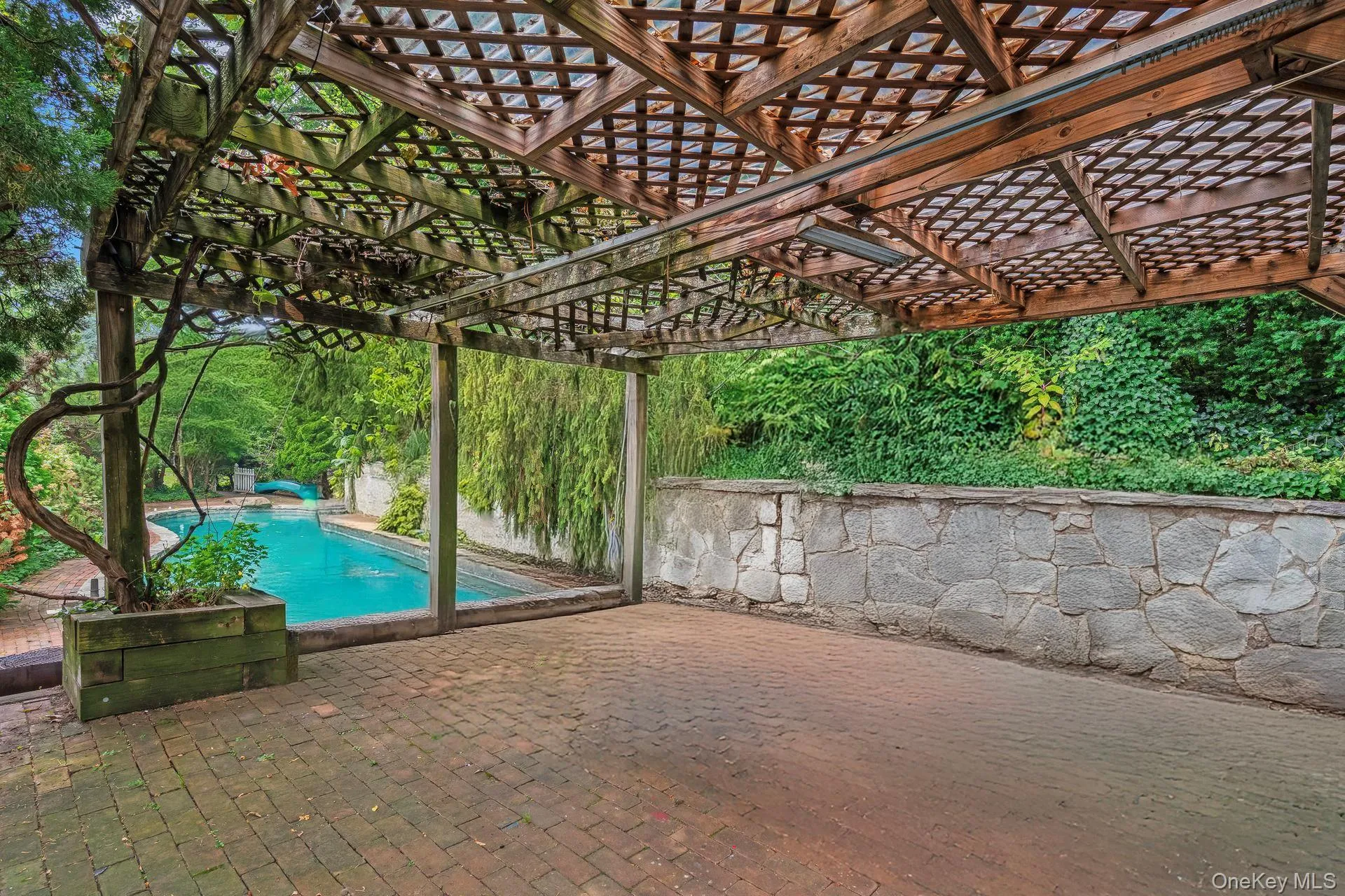 Outdoor pool with a patio area and a pergola Outdoor pool with a patio area and a pergola