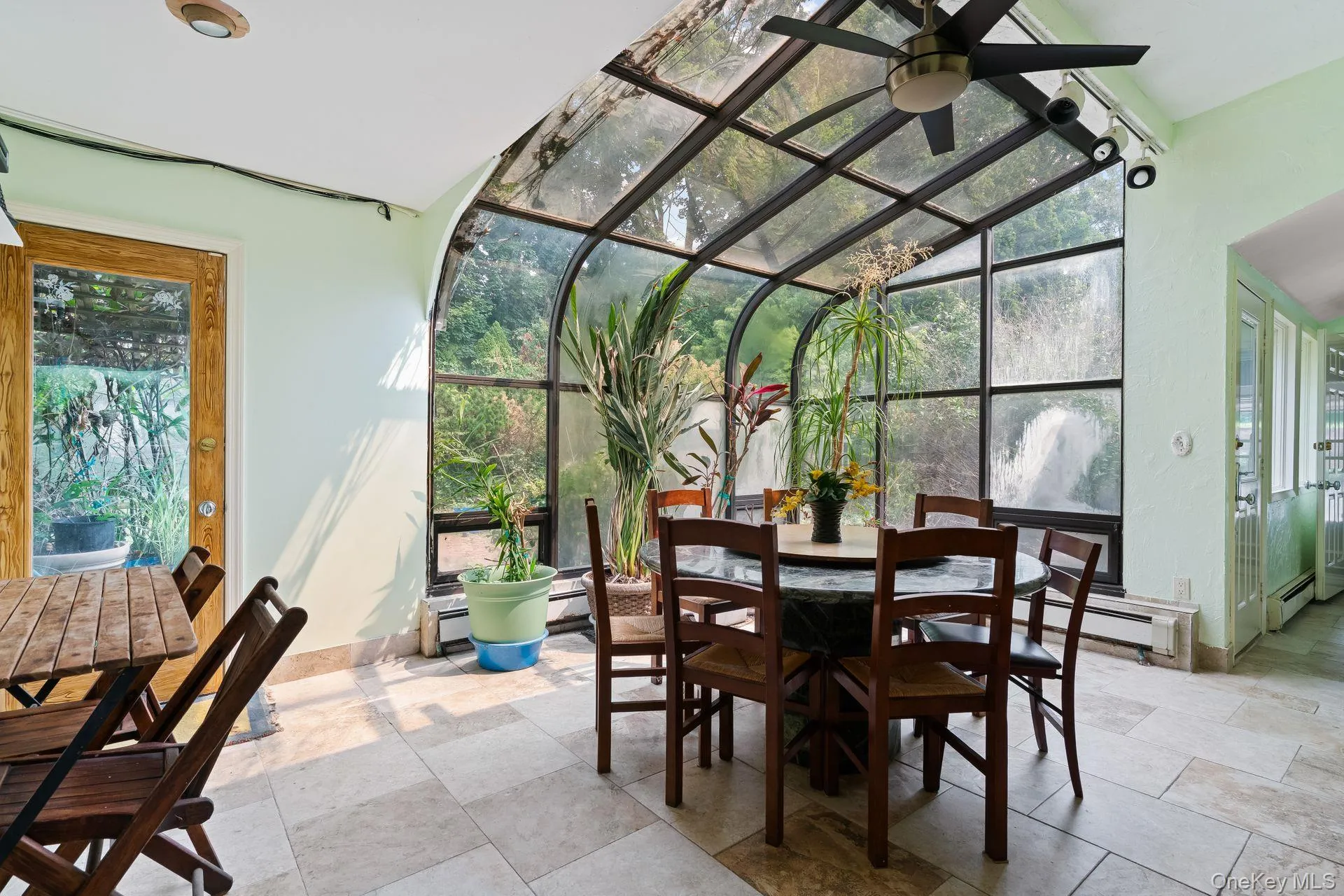 Sunroom featuring a baseboard heating unit and vaulted ceiling Sunroom featuring a baseboard heating unit and vaulted ceiling
