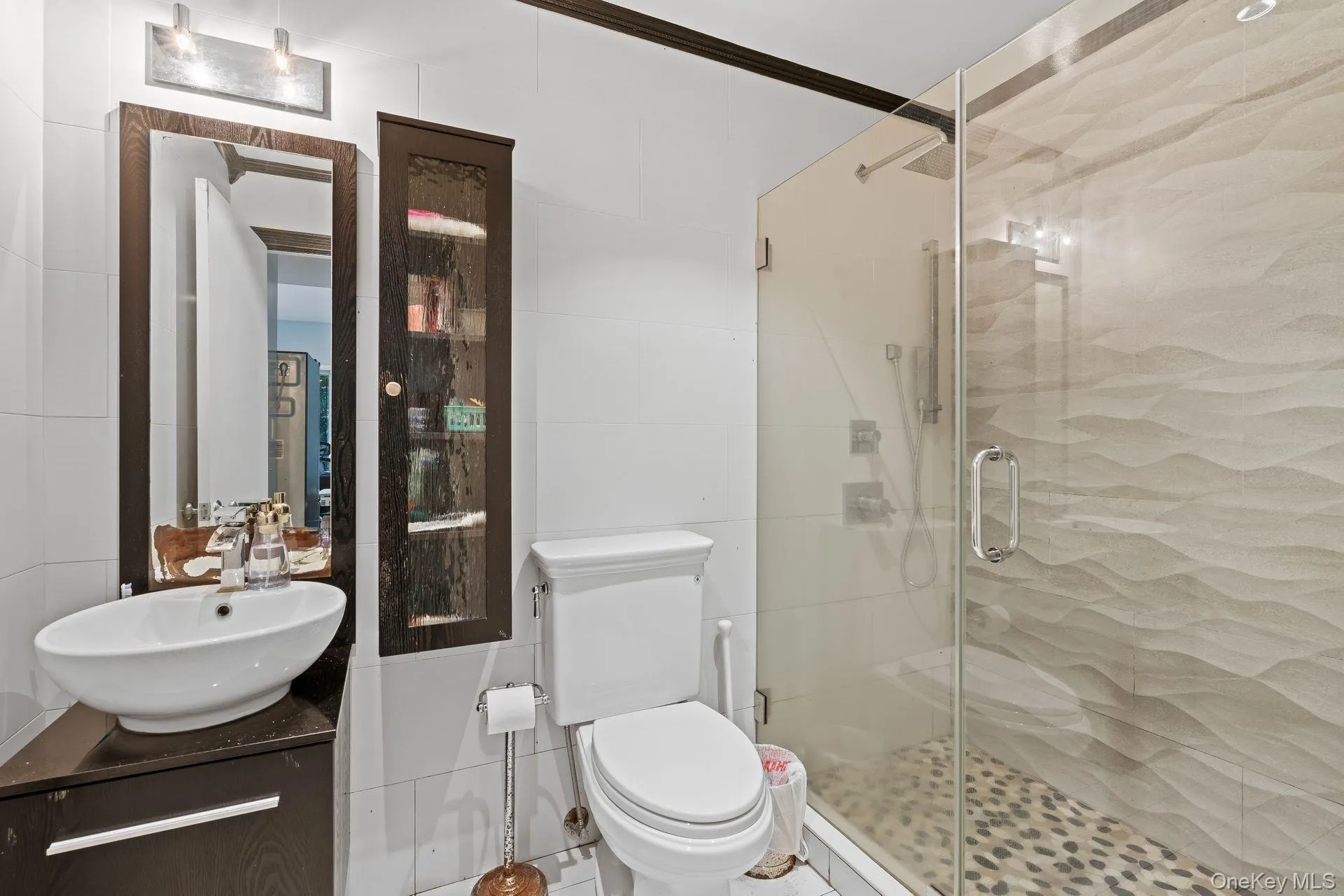 Bathroom featuring tile walls, a shower stall, and vanity Bathroom featuring tile walls, a shower stall, and vanity