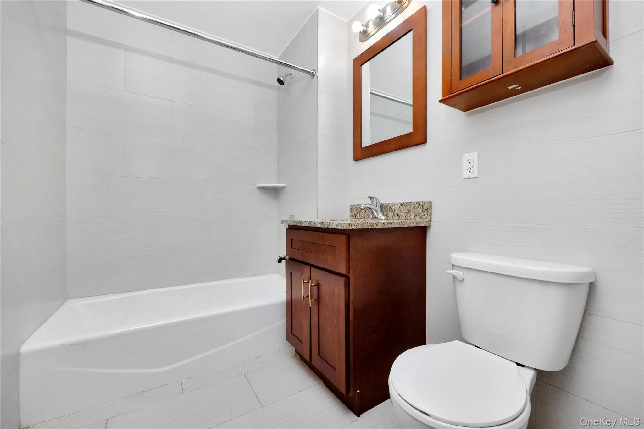 Full bath with toilet, tile patterned floors, vanity, and shower / bathing tub combination Full bath with toilet, tile patterned floors, vanity, and shower / bathing tub combination