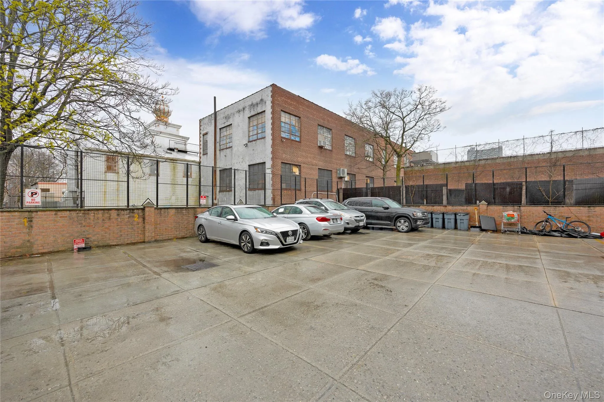 Uncovered parking lot featuring fence Uncovered parking lot featuring fence