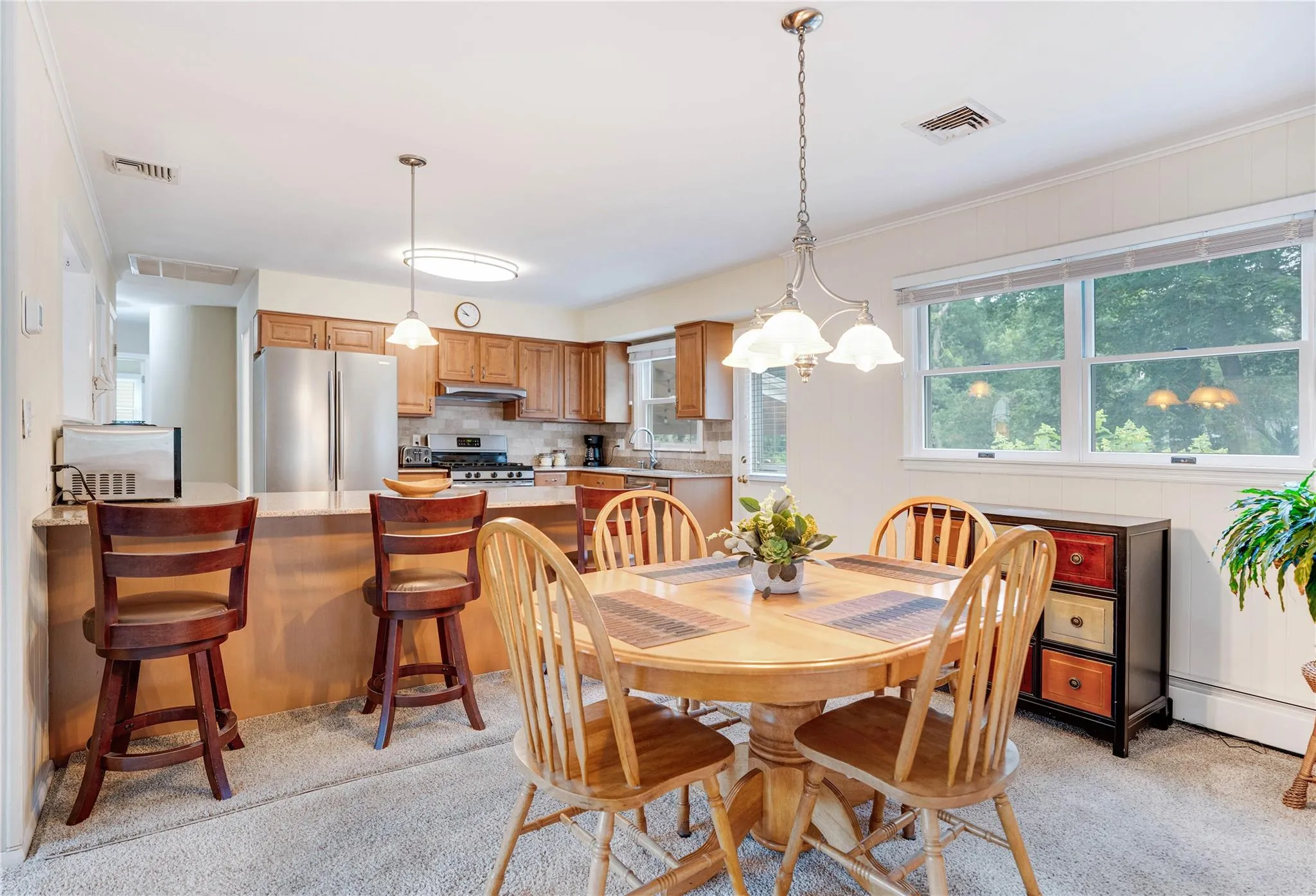 Dining space featuring light colored carpet and baseboard heating