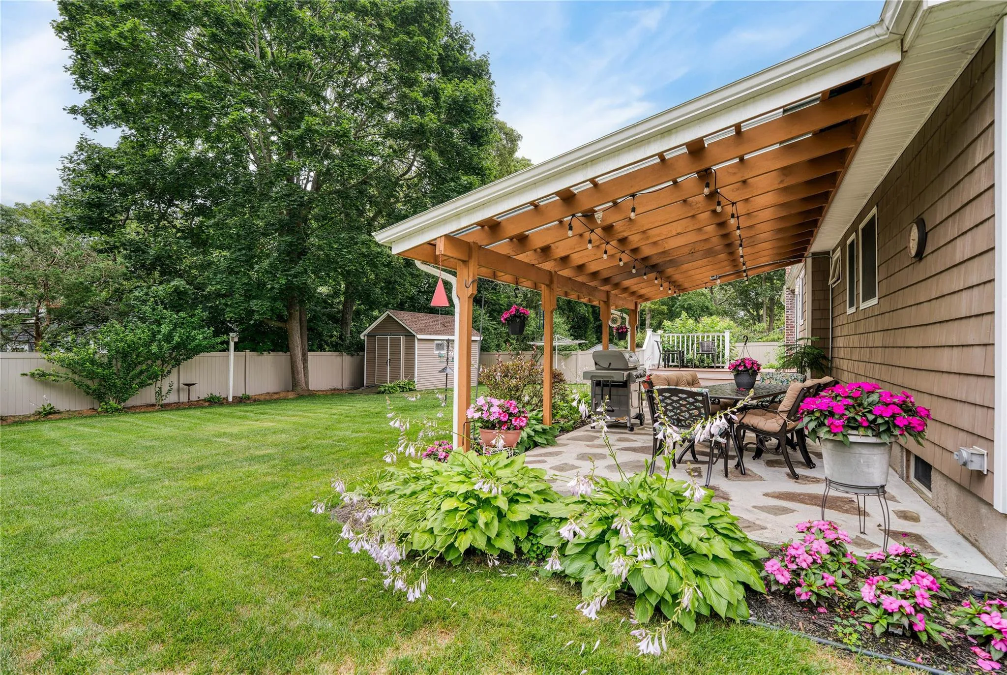 Fenced backyard with a shed, a patio, a pergola, and outdoor dining space