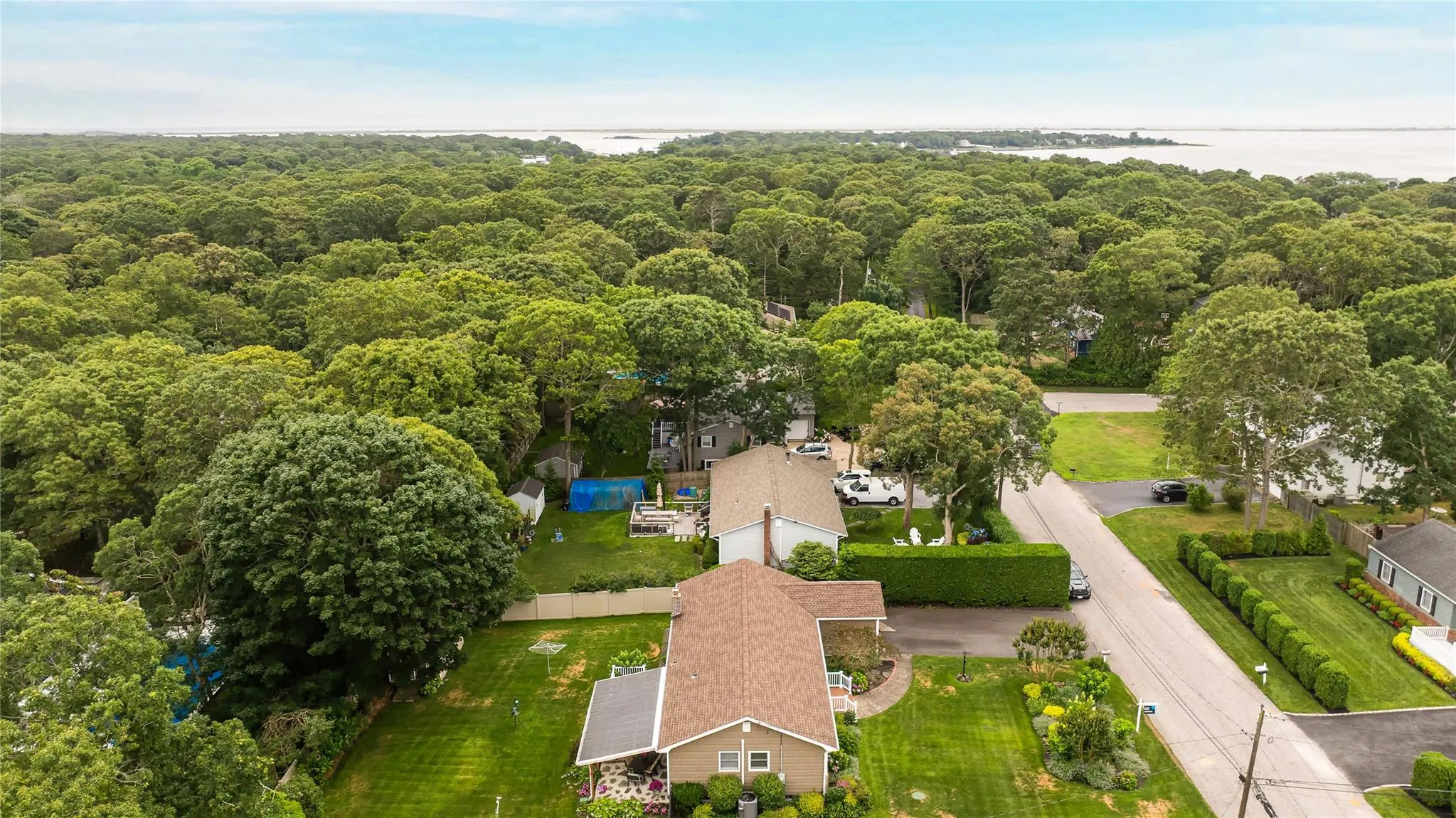 Drone / aerial view of a nearby body of water and a forest
