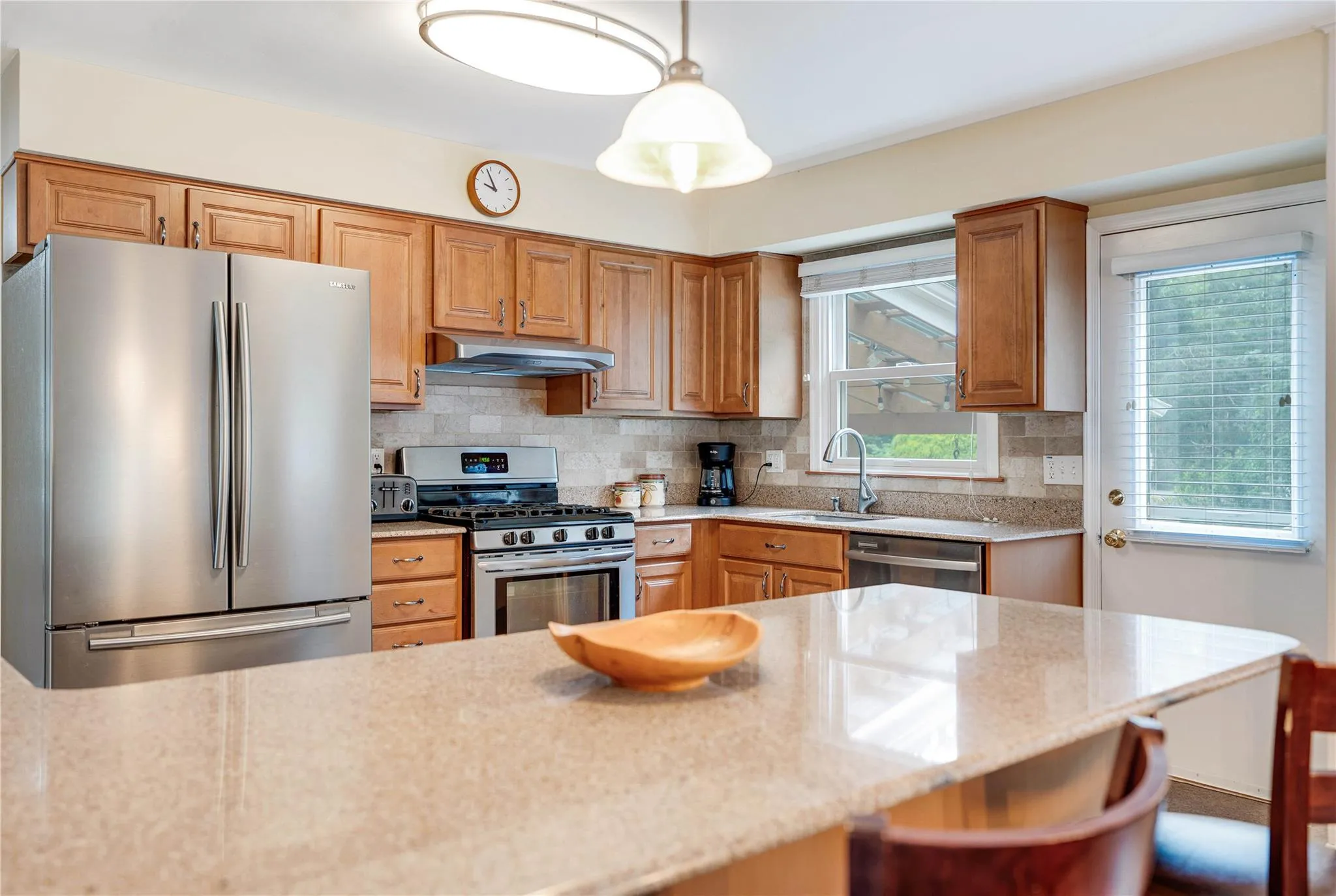 Kitchen with stainless steel appliances, a kitchen bar, plenty of natural light, and backsplash