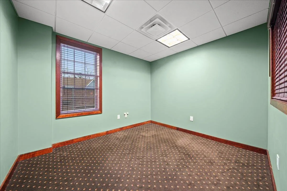 Carpeted empty room featuring a paneled ceiling Carpeted empty room featuring a paneled ceiling