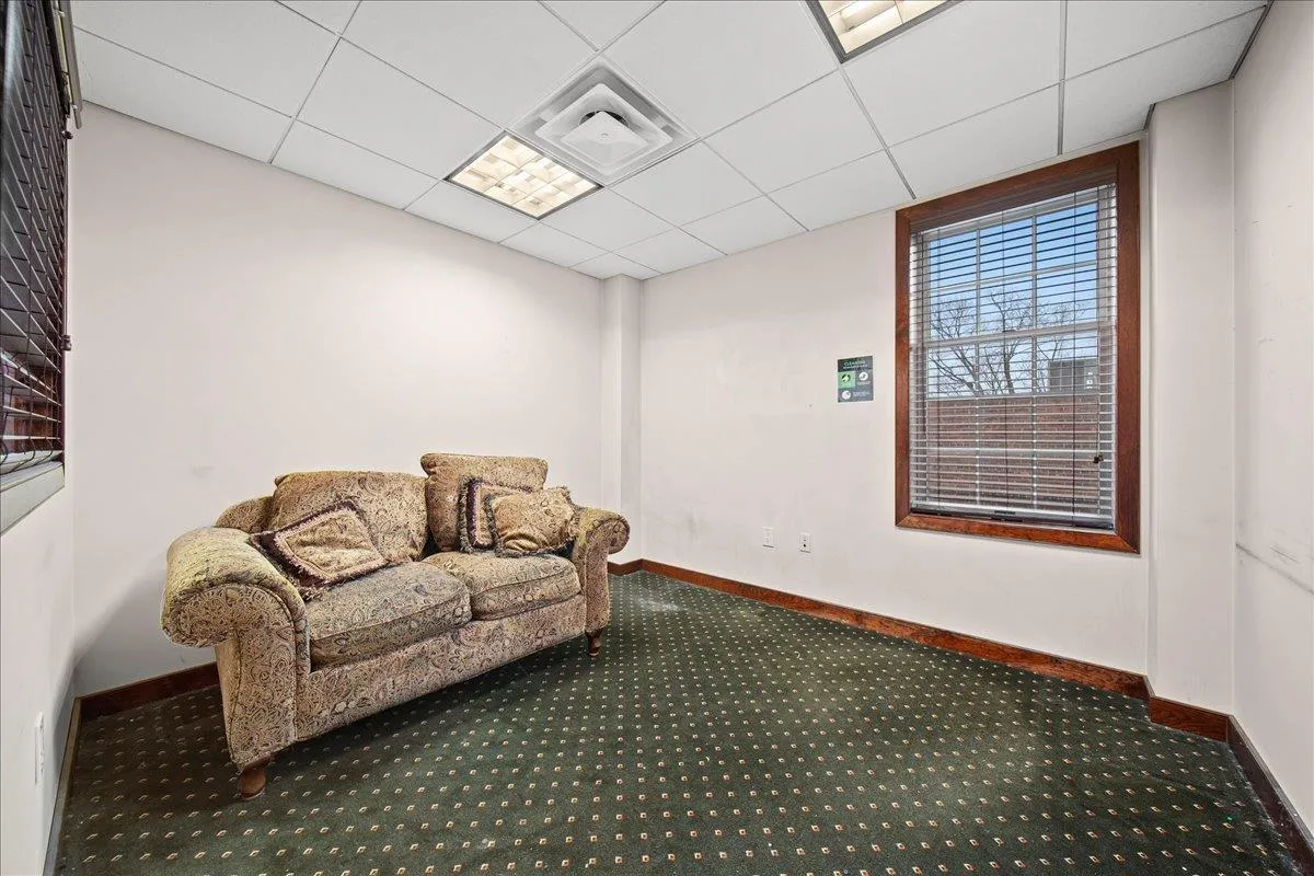 Living area with carpet floors and a drop ceiling Living area with carpet floors and a drop ceiling