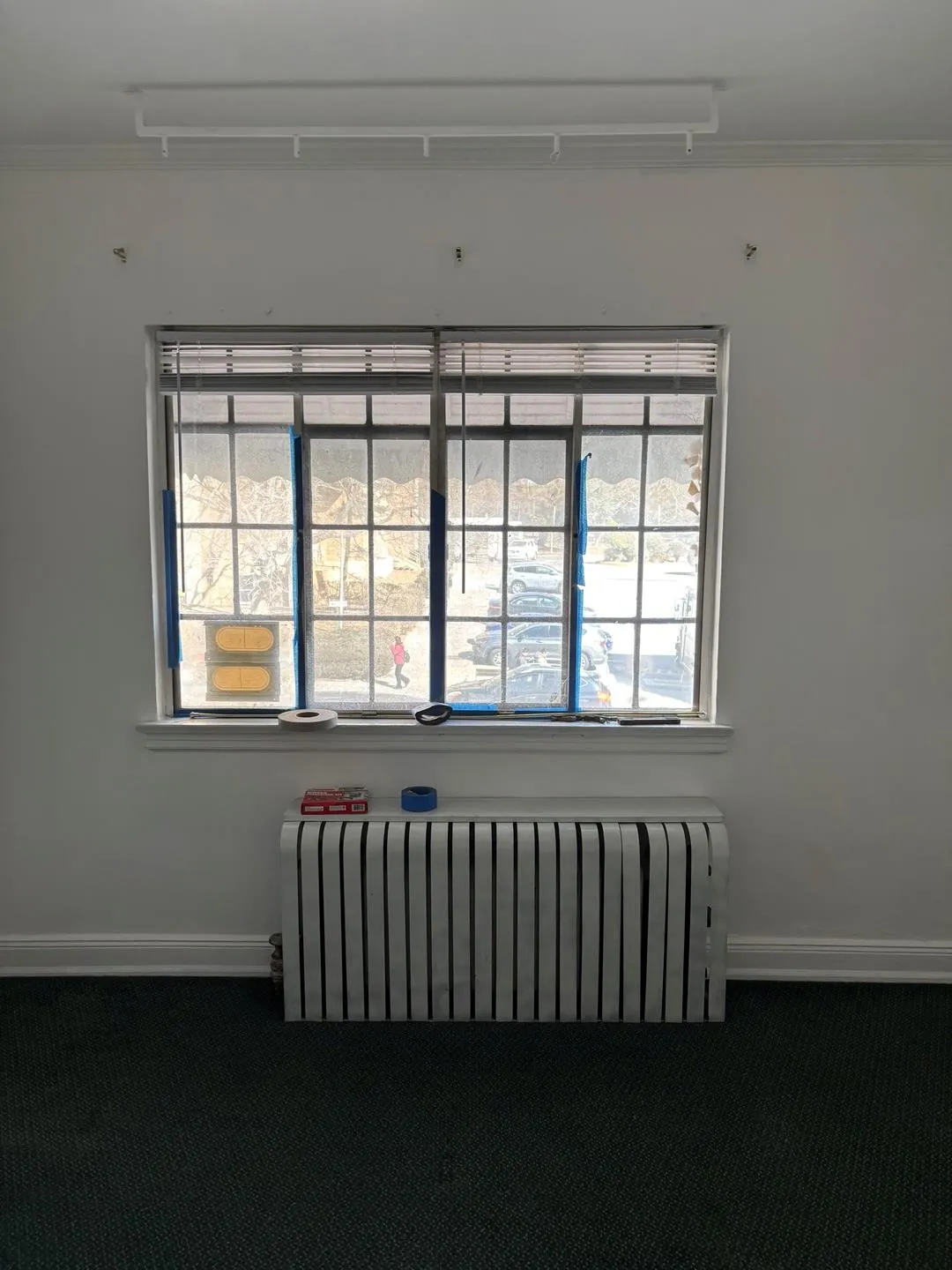 Empty room featuring radiator heating unit, carpet flooring, attic access, and crown molding Empty room featuring radiator heating unit, carpet flooring, attic access, and crown molding