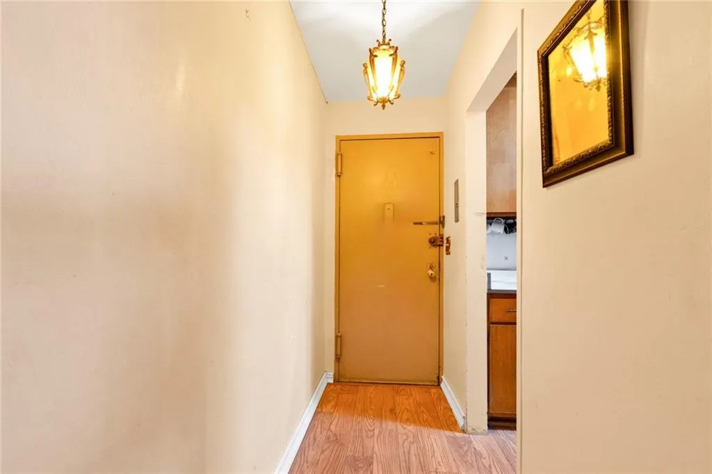 Doorway to outside featuring light wood finished floors and baseboards Doorway to outside featuring light wood finished floors and baseboards