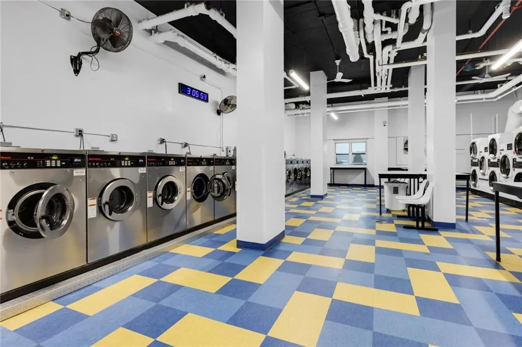 Communal laundry room featuring separate washer and dryer and tile patterned floors Communal laundry room featuring separate washer and dryer and tile patterned floors